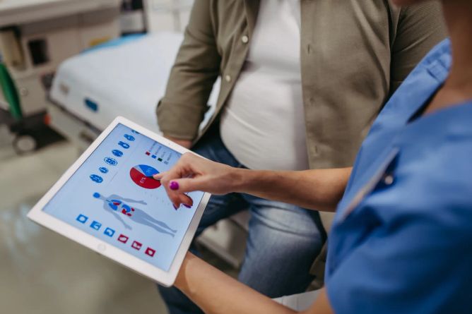 Zdravotní sestra vysvětlující zvýšenou hladinu cholesterolu. Zdravotní sestra vysvětlující zvýšenou hladinu cholesterolu.