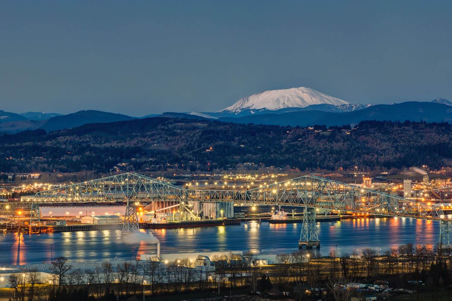 Image of the ports on the Columbia River in Longview, WA at dusk with Mt. St. Helens in the background