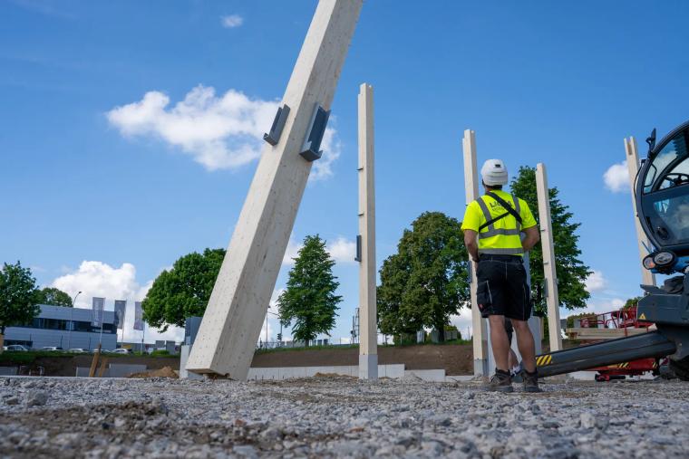 Monteur richtet eine Holzstütze auf der Baustelle aus