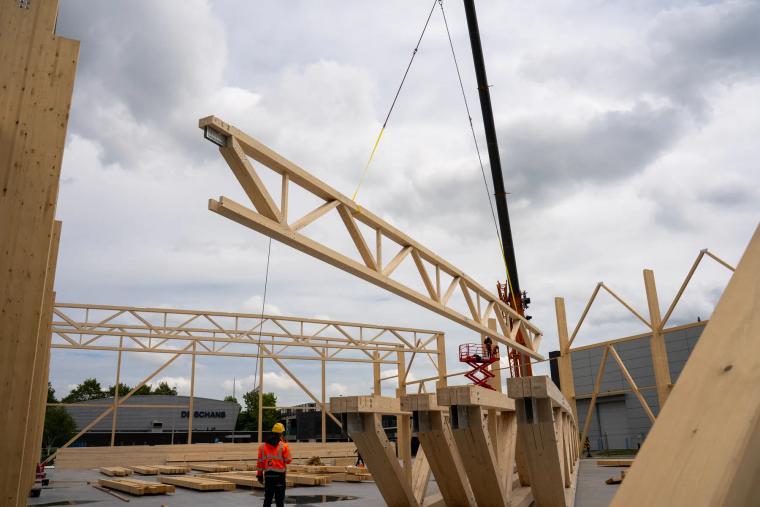 Fachwerkträger schwebt am Kran über der Baustelle