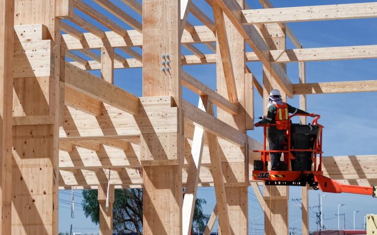 Monteur auf einer Hebebühne im Holztragwerk