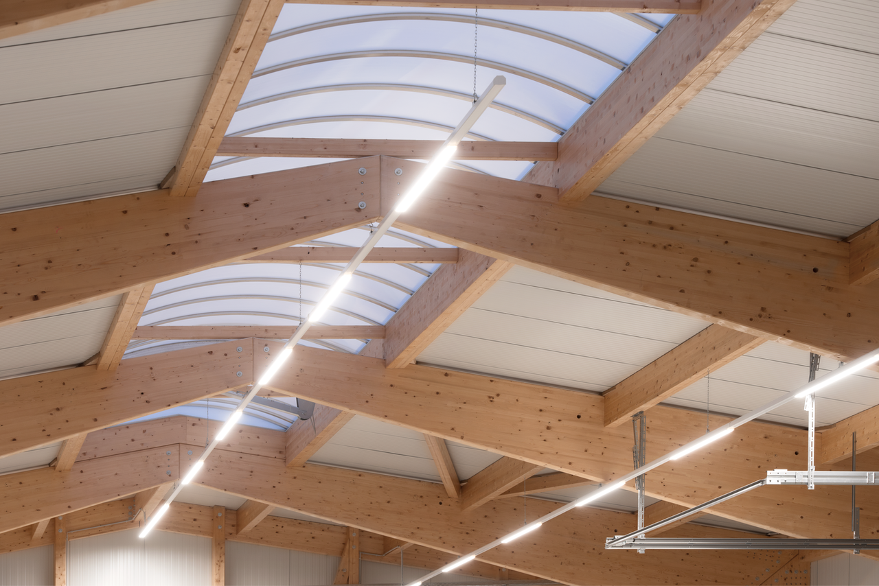 Bright commercial hall with continuous ridge light and timber roof structure