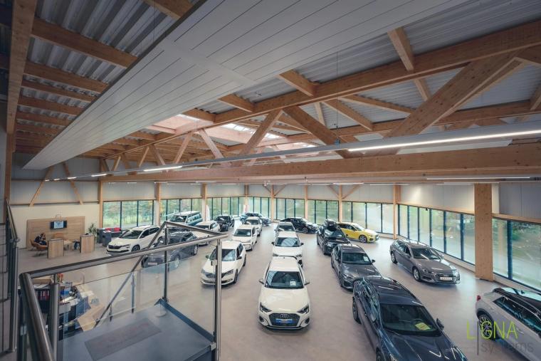 Blick von der Galerieebene über den Showroom auf die hölzernen Fachwerkbinder des Dachs