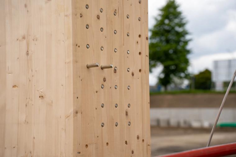 Detail des ausgeklinkten Stützenkopfes einer Holz-Rohrstütze gegen blauen Himmel
