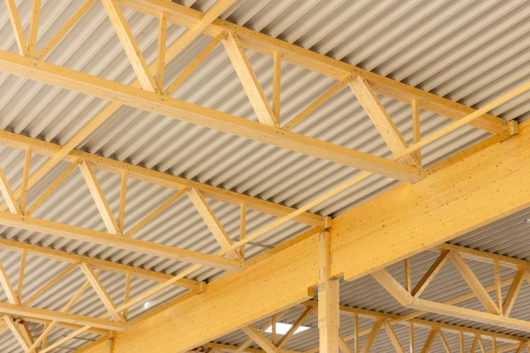 View from below of the glulam trusses with purlins and trapezoidal sheet roof decking