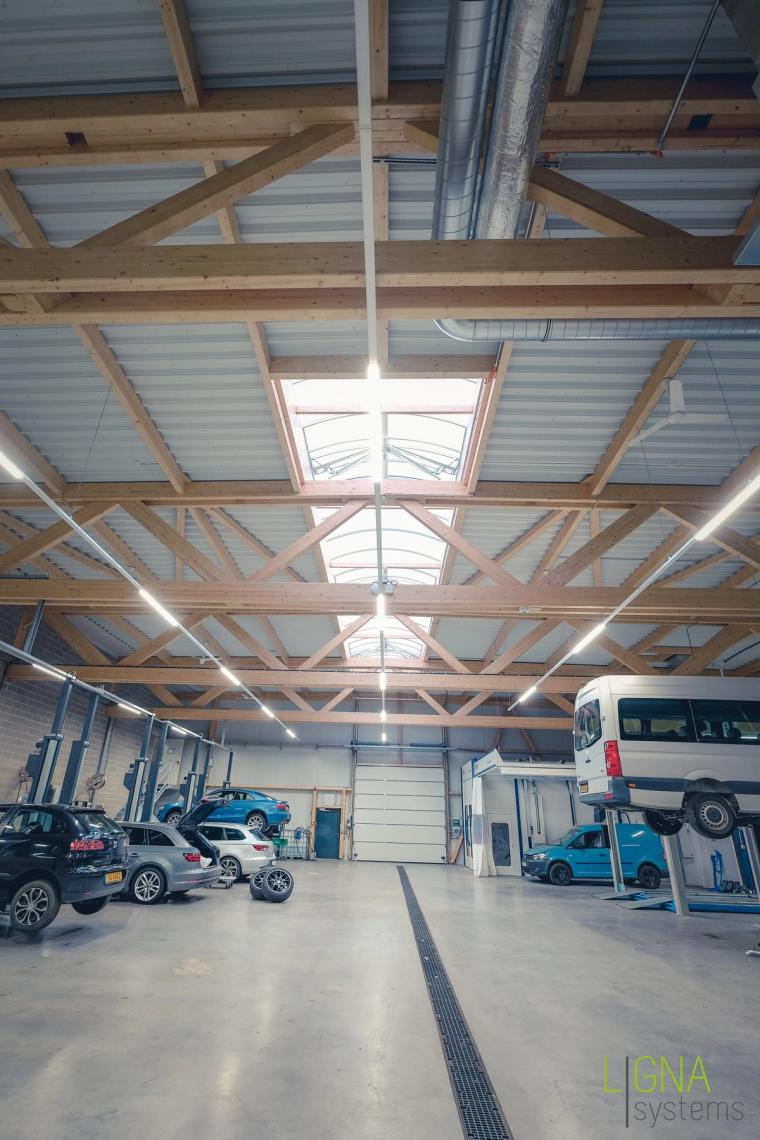 Werkstatt mit Hebebühnen und Dachoberlicht zwischen den Holzbindern, Hochformat