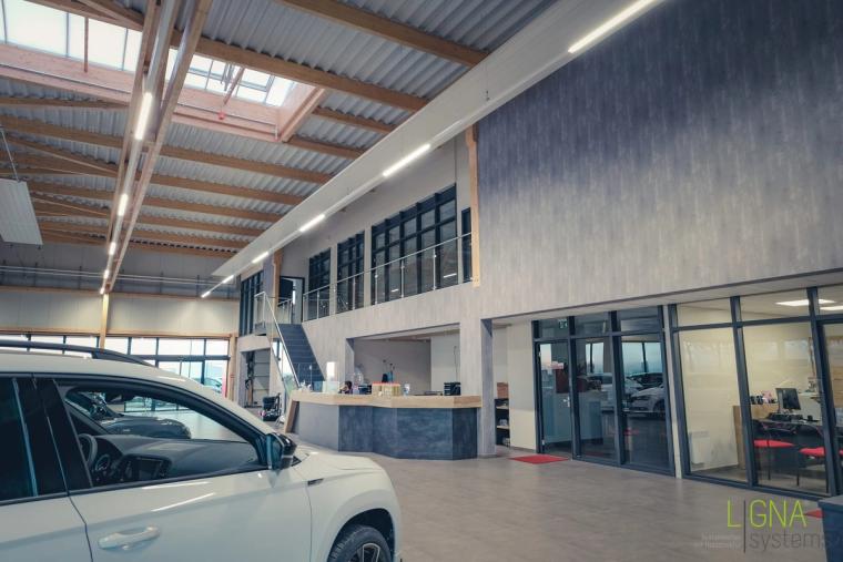 Empfangsbereich mit Tresen und darüberliegender Büro-Galerieebene im Autohaus