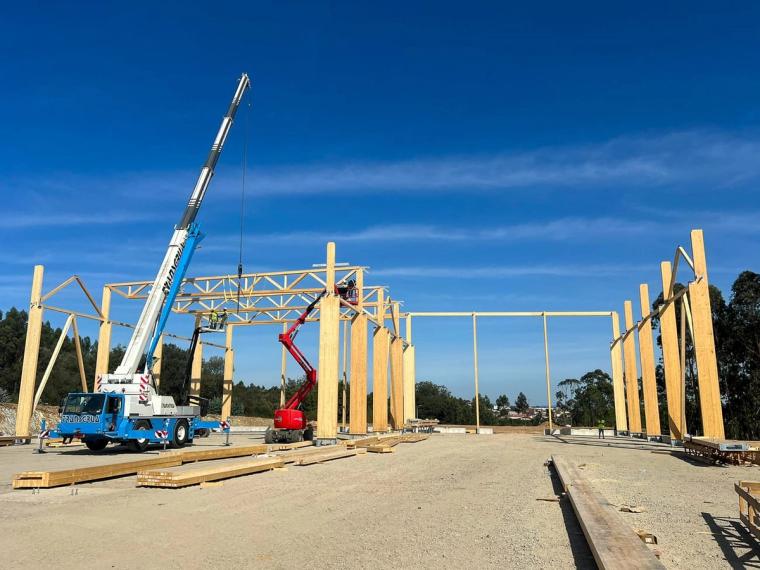 Innenraum der Halle während der Montage mit Hubsteiger, Stützenreihen und einzelnen eingehängten Fachwerkbindern