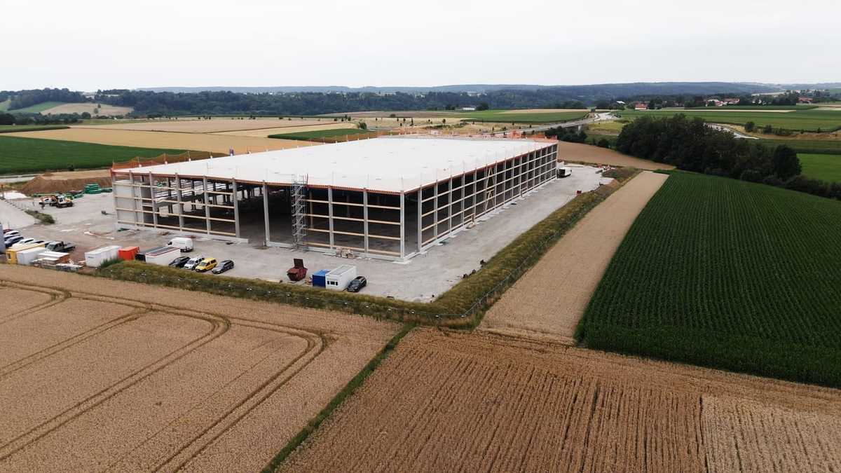 Aerial view of the warehouse and cold store in Obertaufkirchen during shell construction, concrete frame with the roof already installed between fields