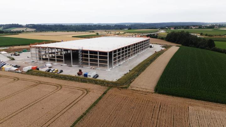 Aerial view of the warehouse and cold store in Obertaufkirchen during shell construction, concrete frame with the roof already installed between fields