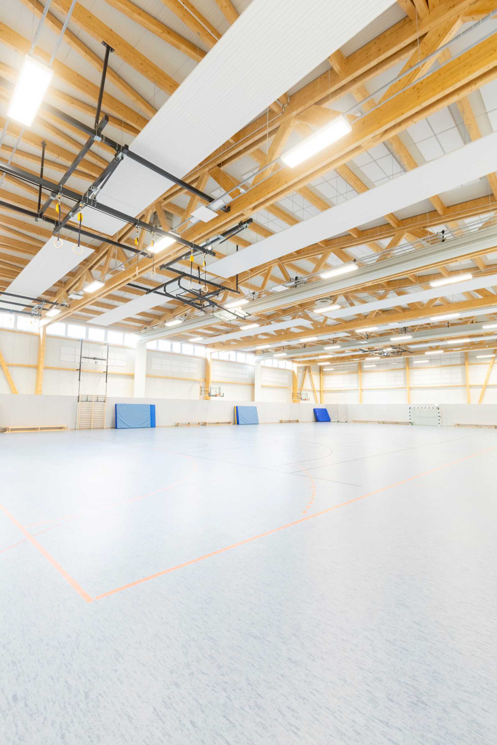 Sporthalle Prüm mit weitgespanntem Holz-Dachtragwerk und sichtbaren Leimholzbindern, Innenansicht