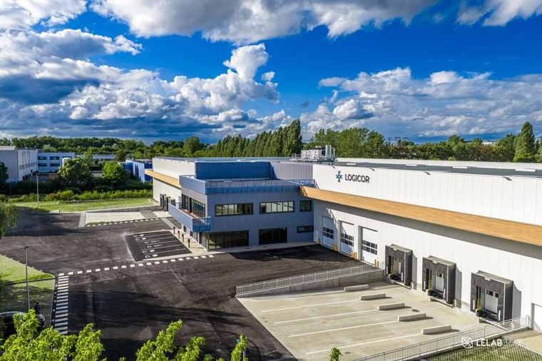 Luftbild des fertigen Logistikzentrums mit Logicor-Schriftzug, Verladetoren und holzverkleidetem Vordach