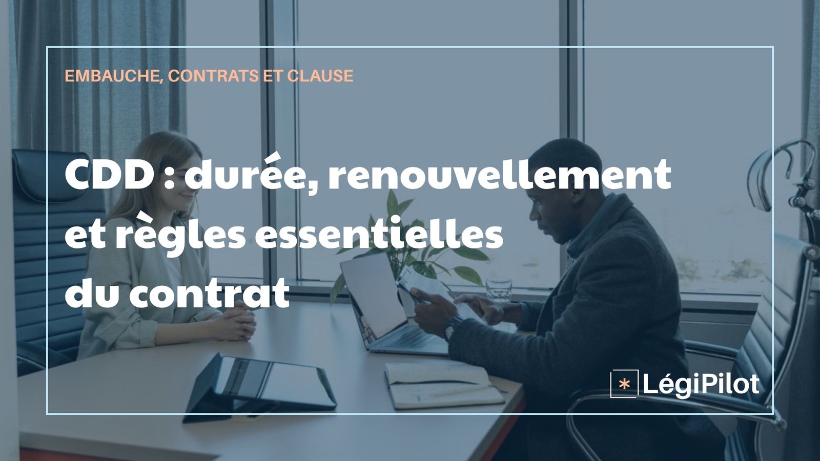 Un homme et une femme face à face assis à un bureau devant un ordinateur