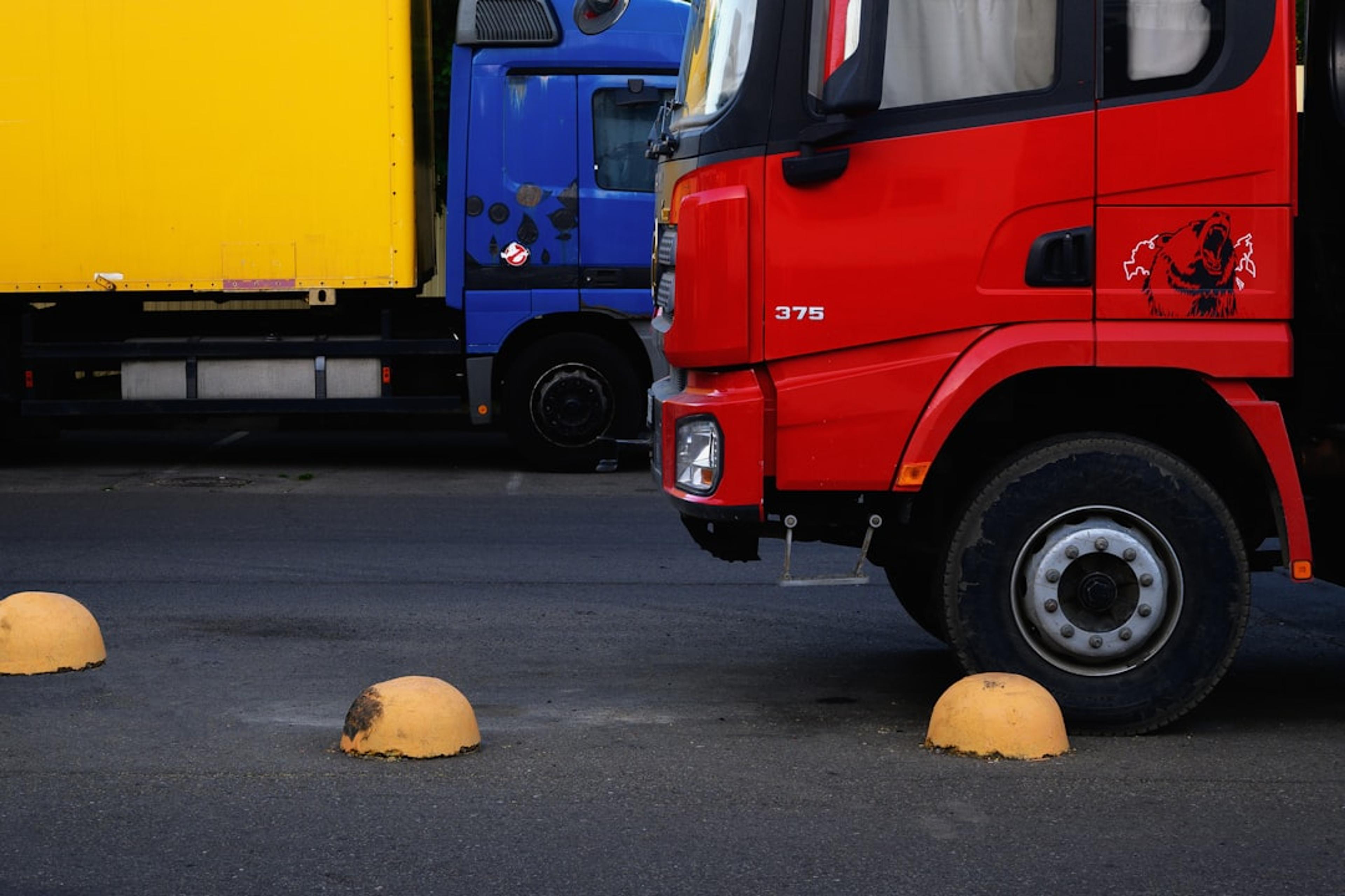 A red truck parked next to a yellow truck