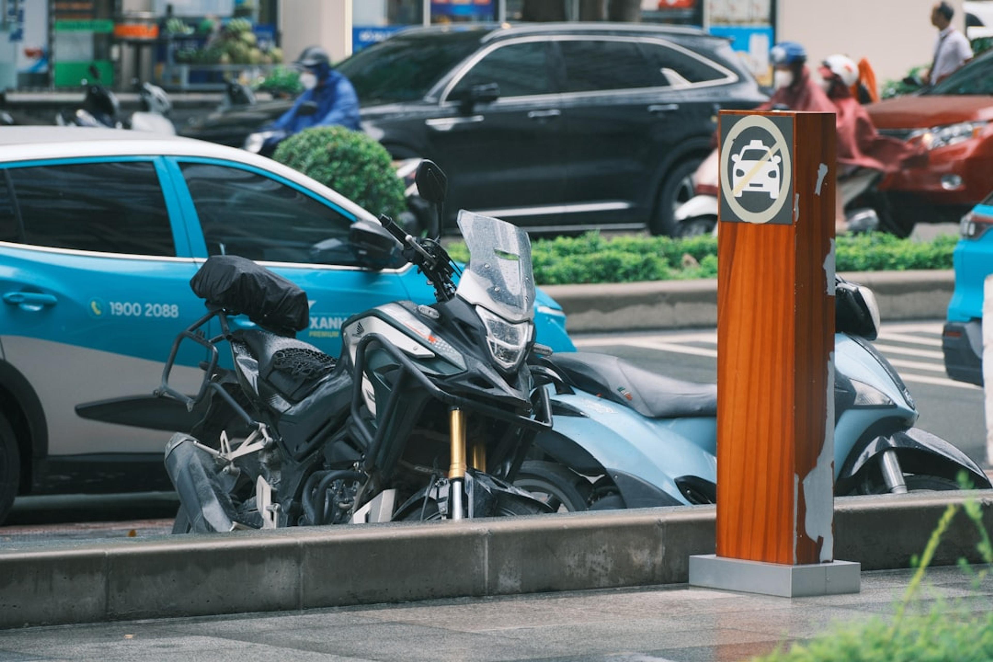 A motorcycle parked near an electric vehicle charger.