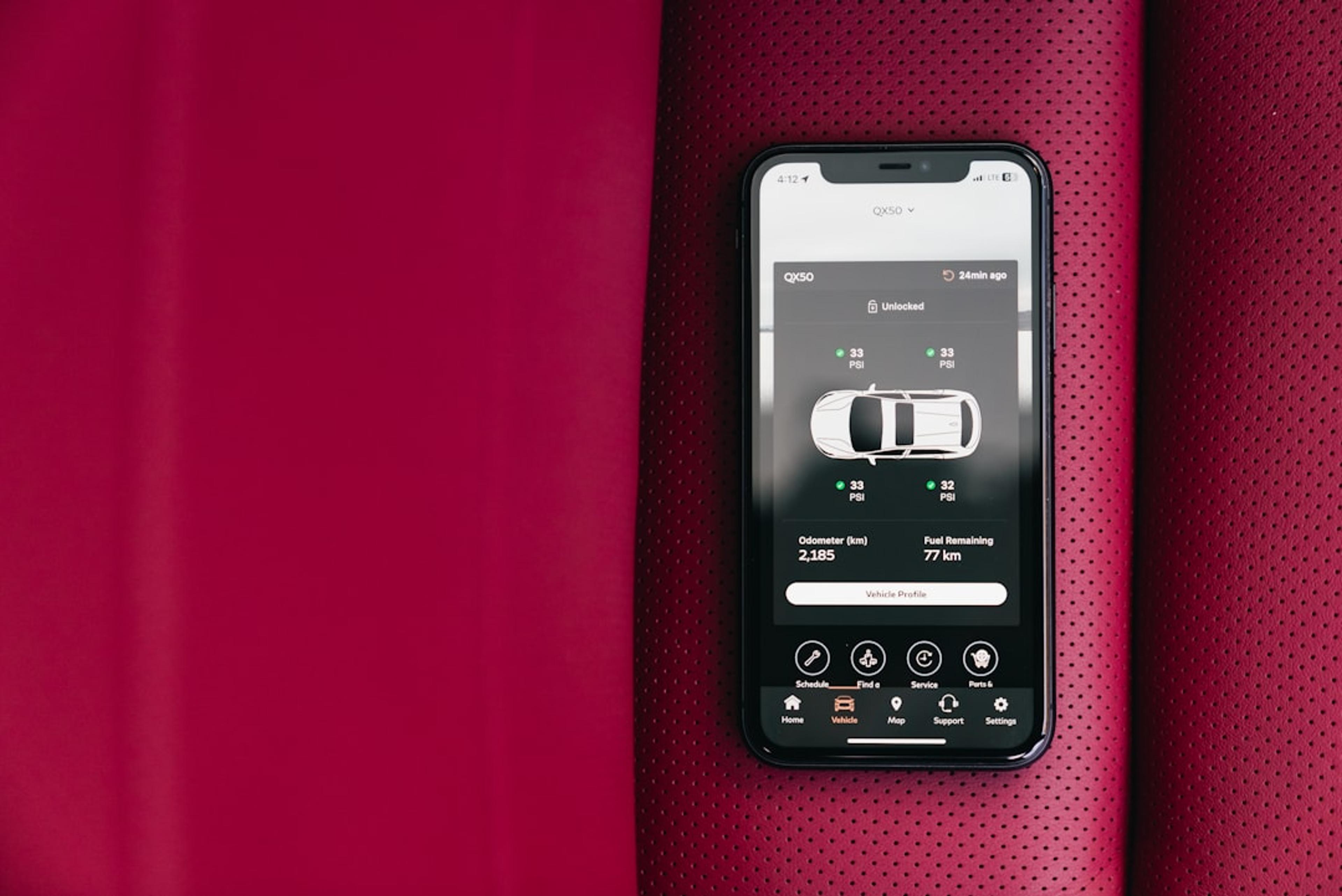Smartphone displaying car control app on red seat