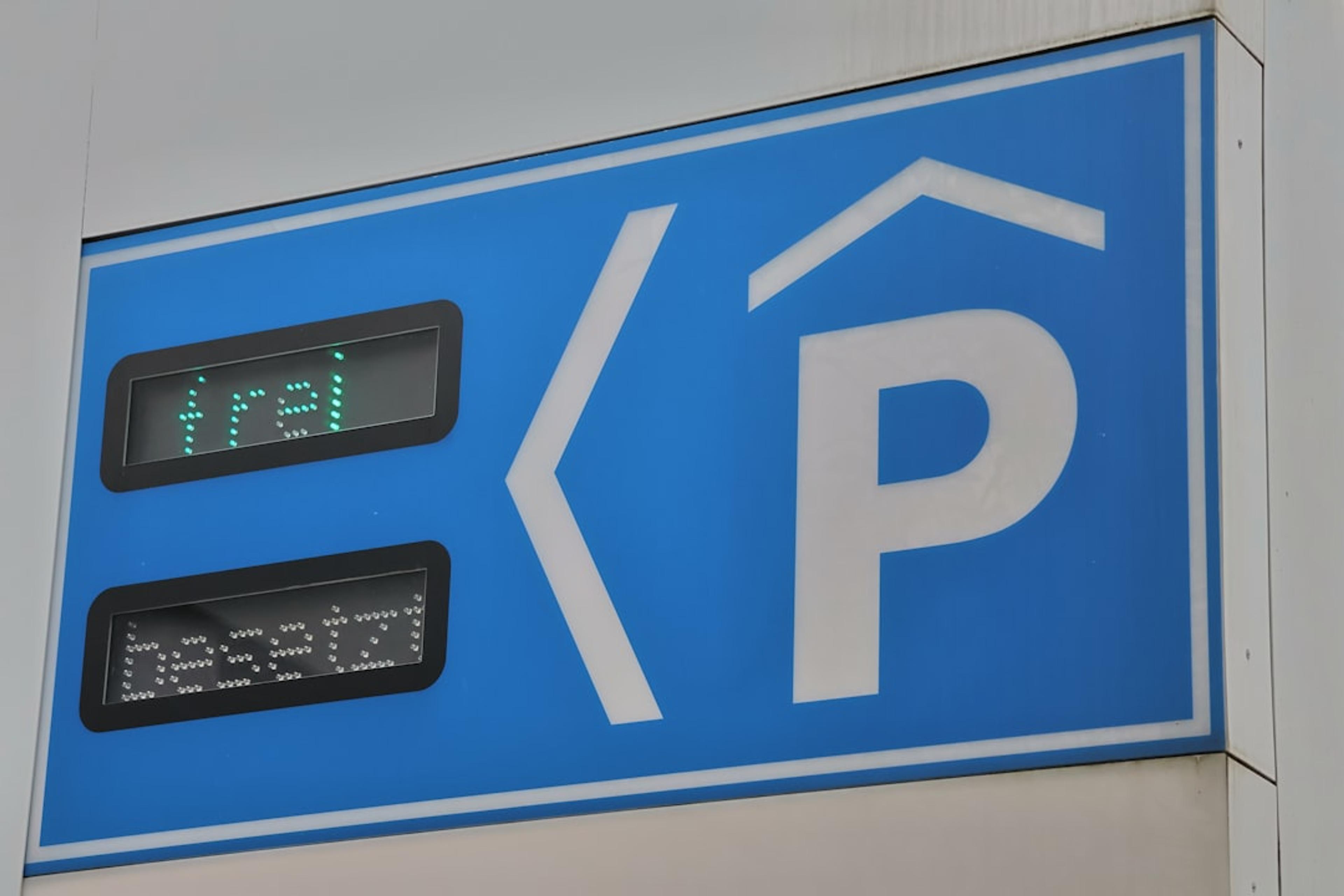 A blue parking sign with a clock on it