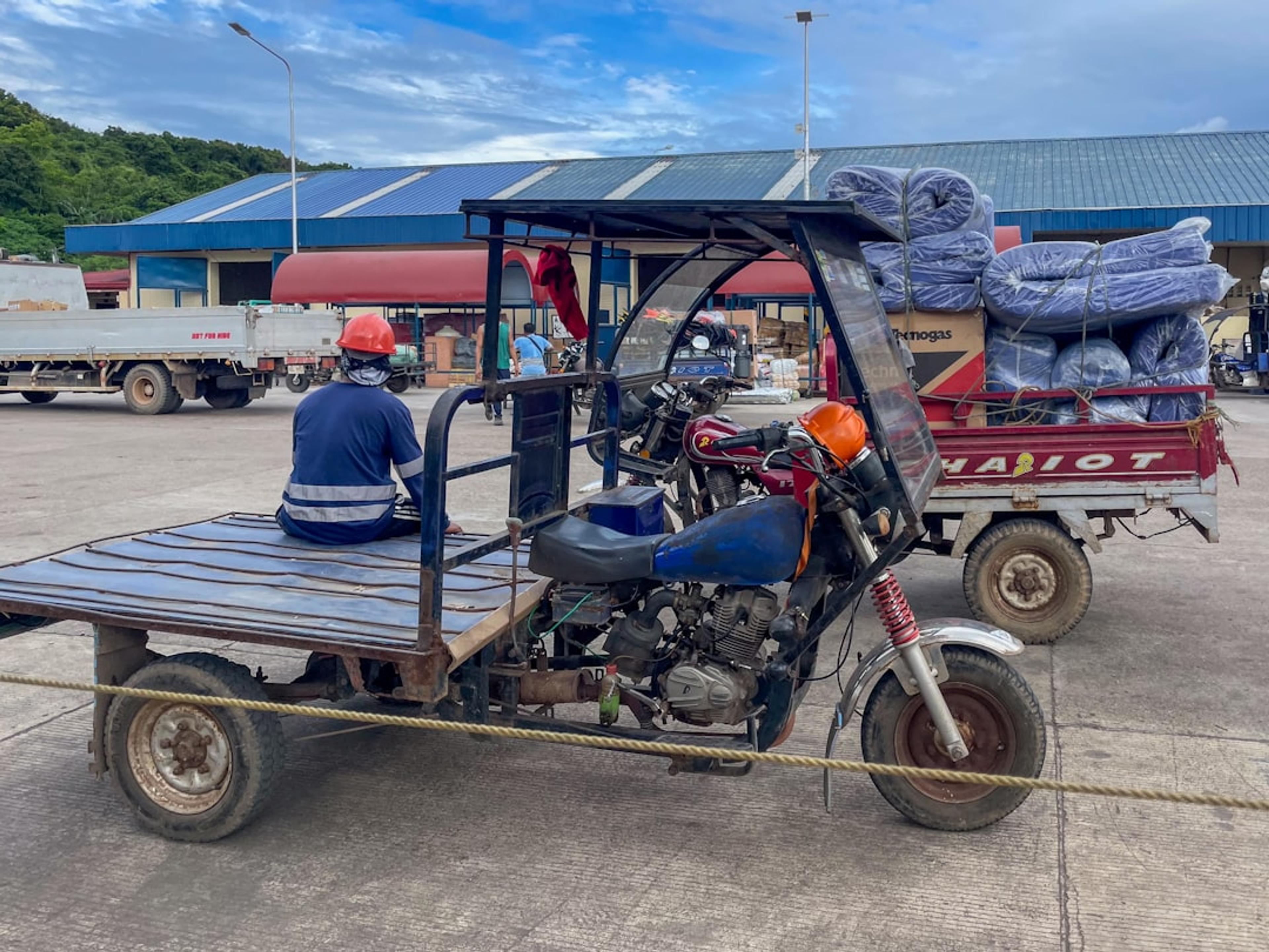 Man sits on a three-wheeled cargo vehicle