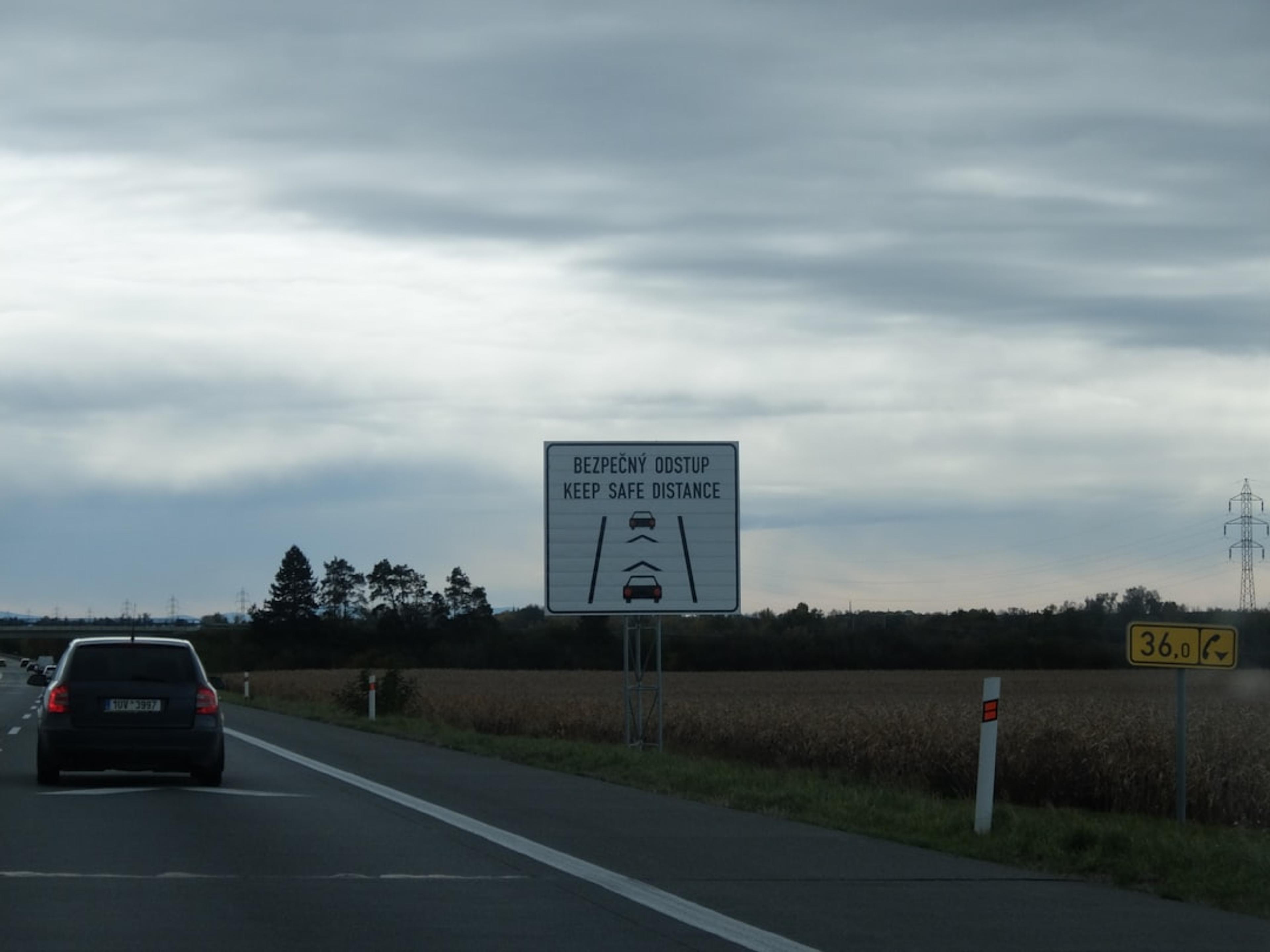 Road sign showing distance between cars