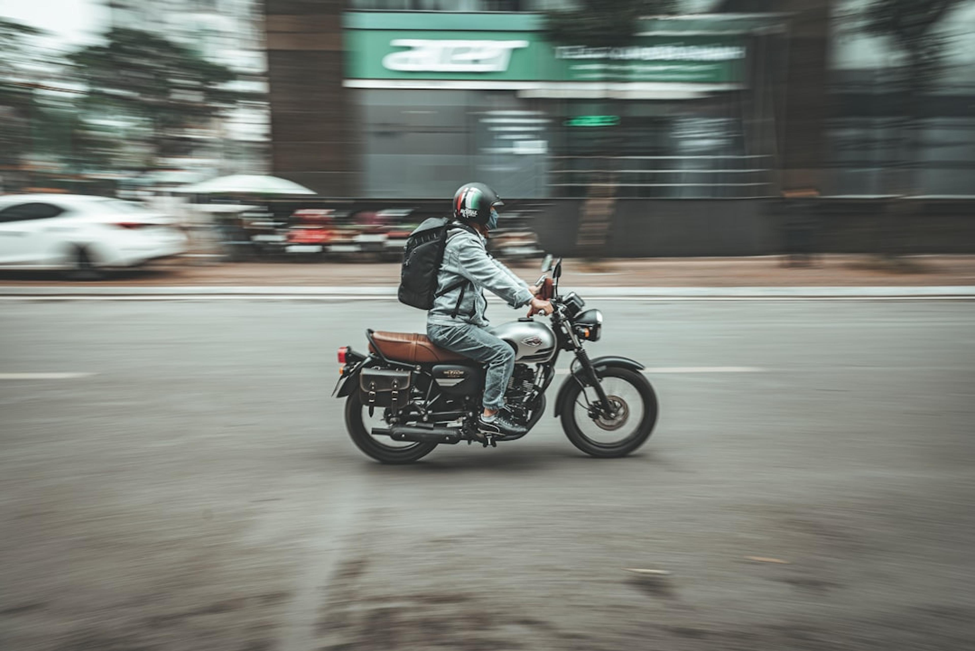 a man riding a motorcycle down a street