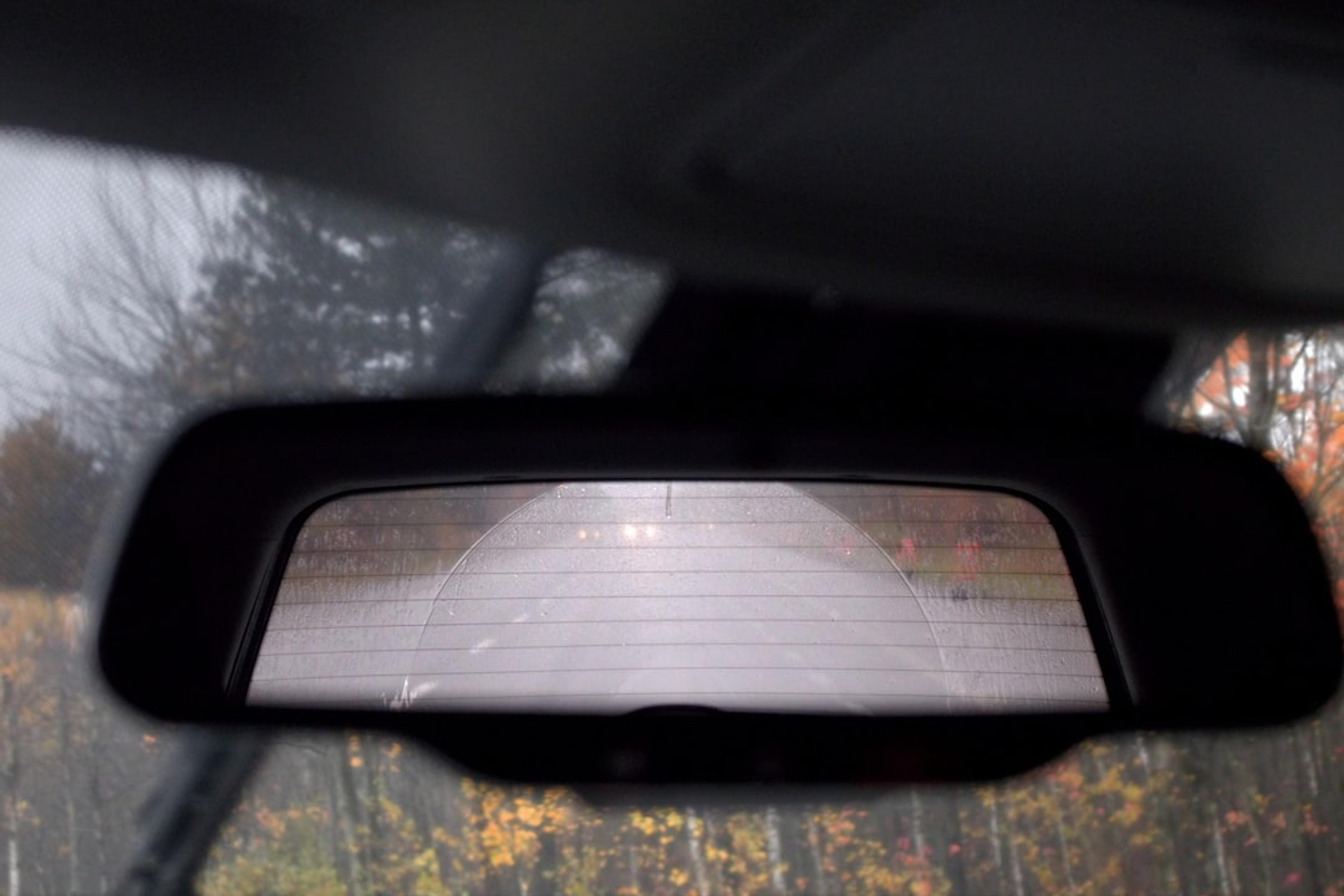 a rear view mirror of a car with trees in the background