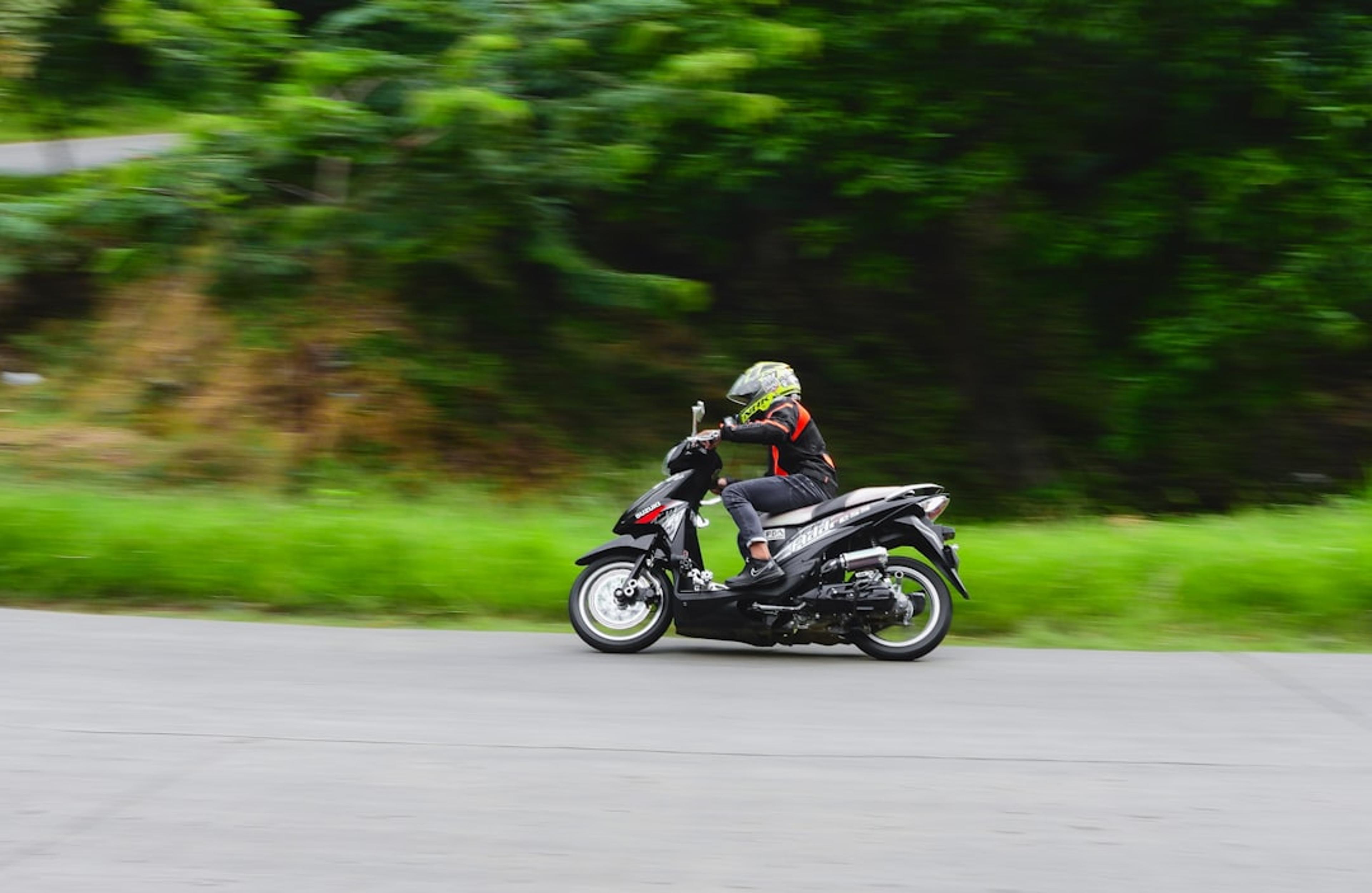 man riding motorcycle on road during daytime