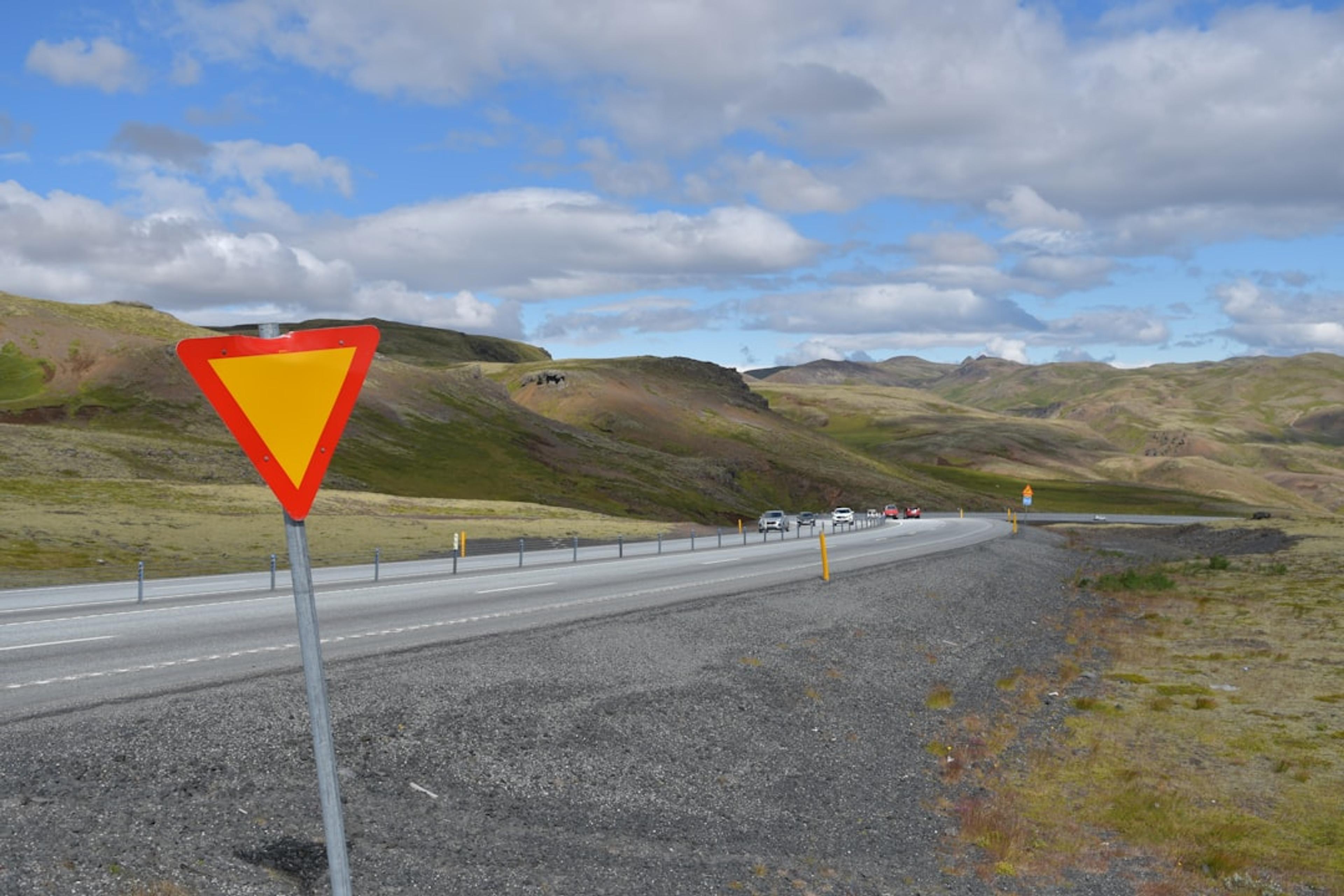 Yield sign on a winding road through the hills.