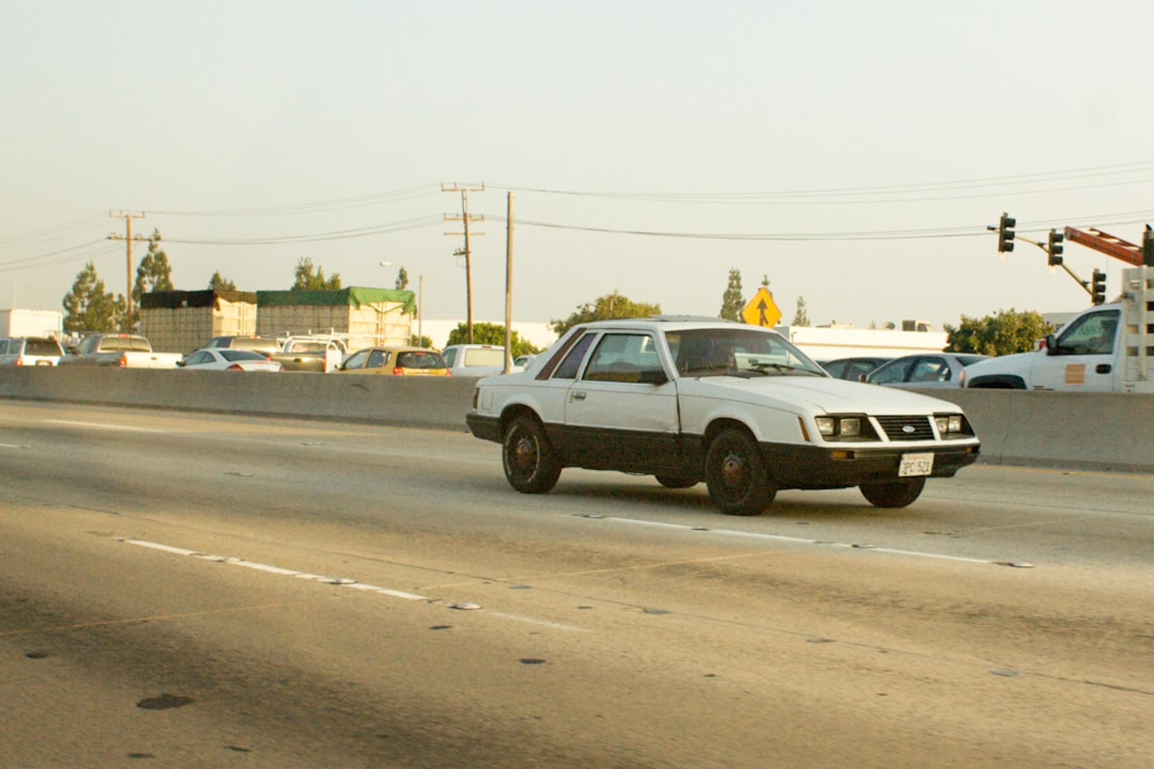 White and black car driving on a highway.