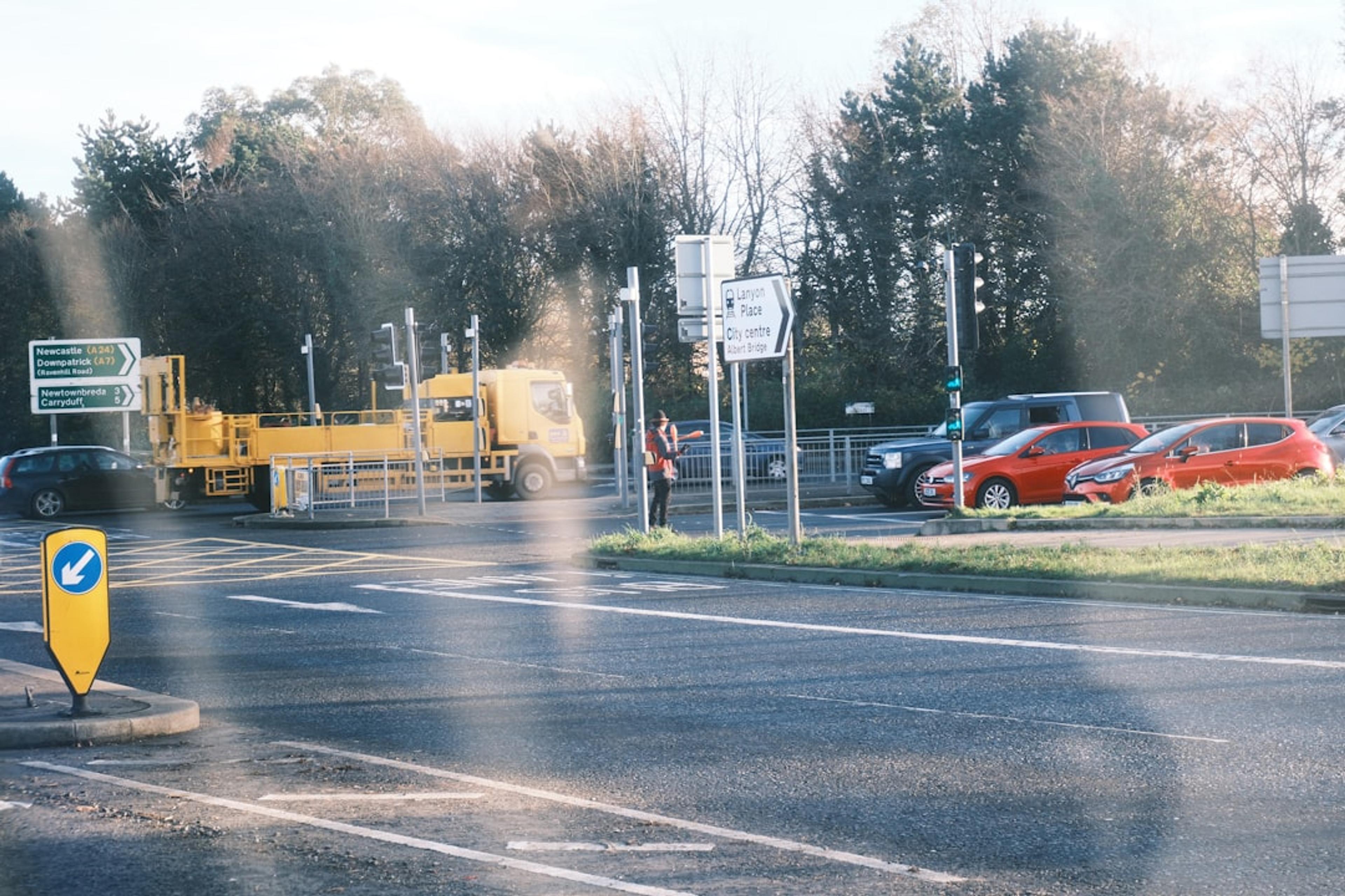 Yellow truck and cars at a road intersection.