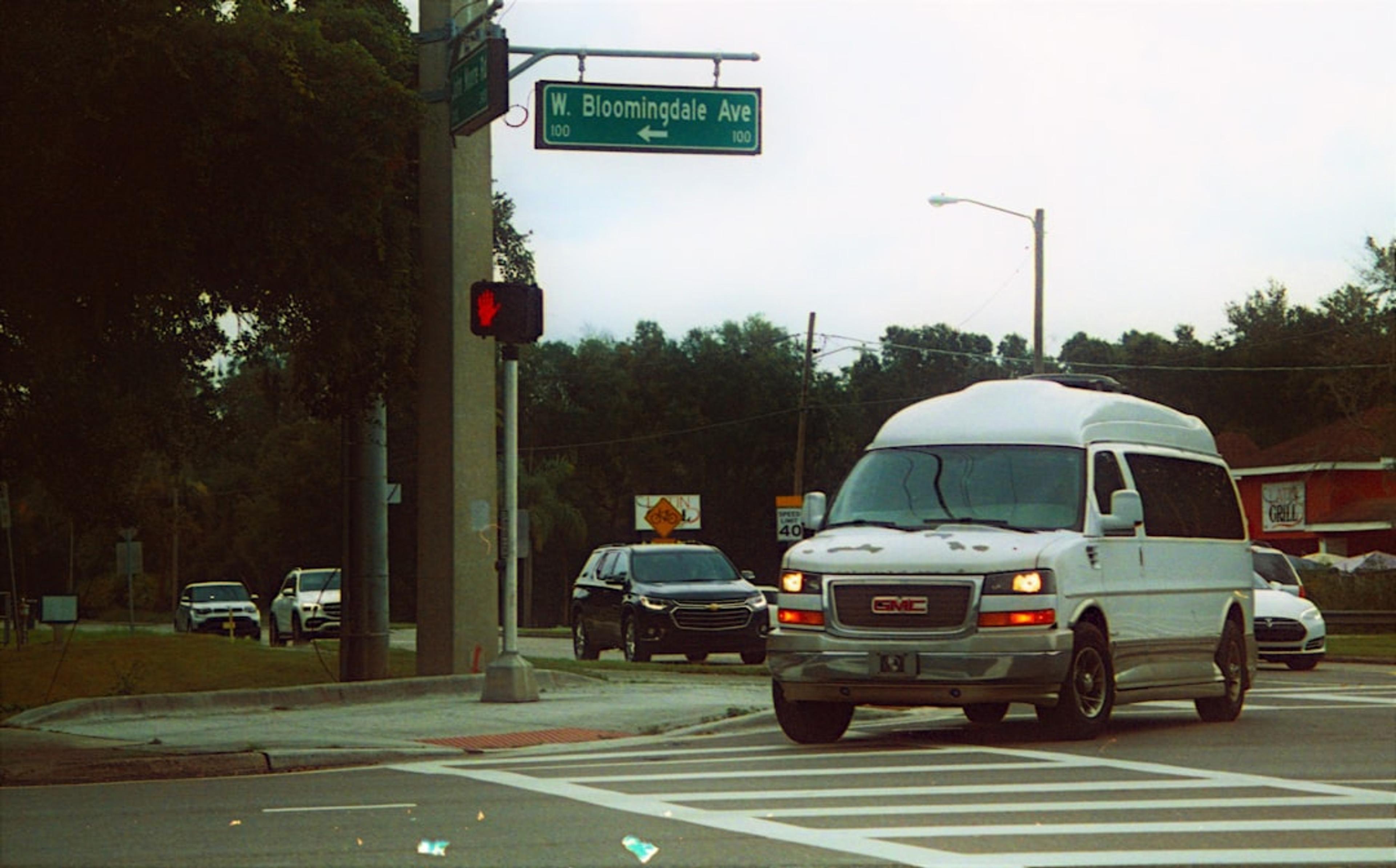 a white van driving down a street next to a traffic light