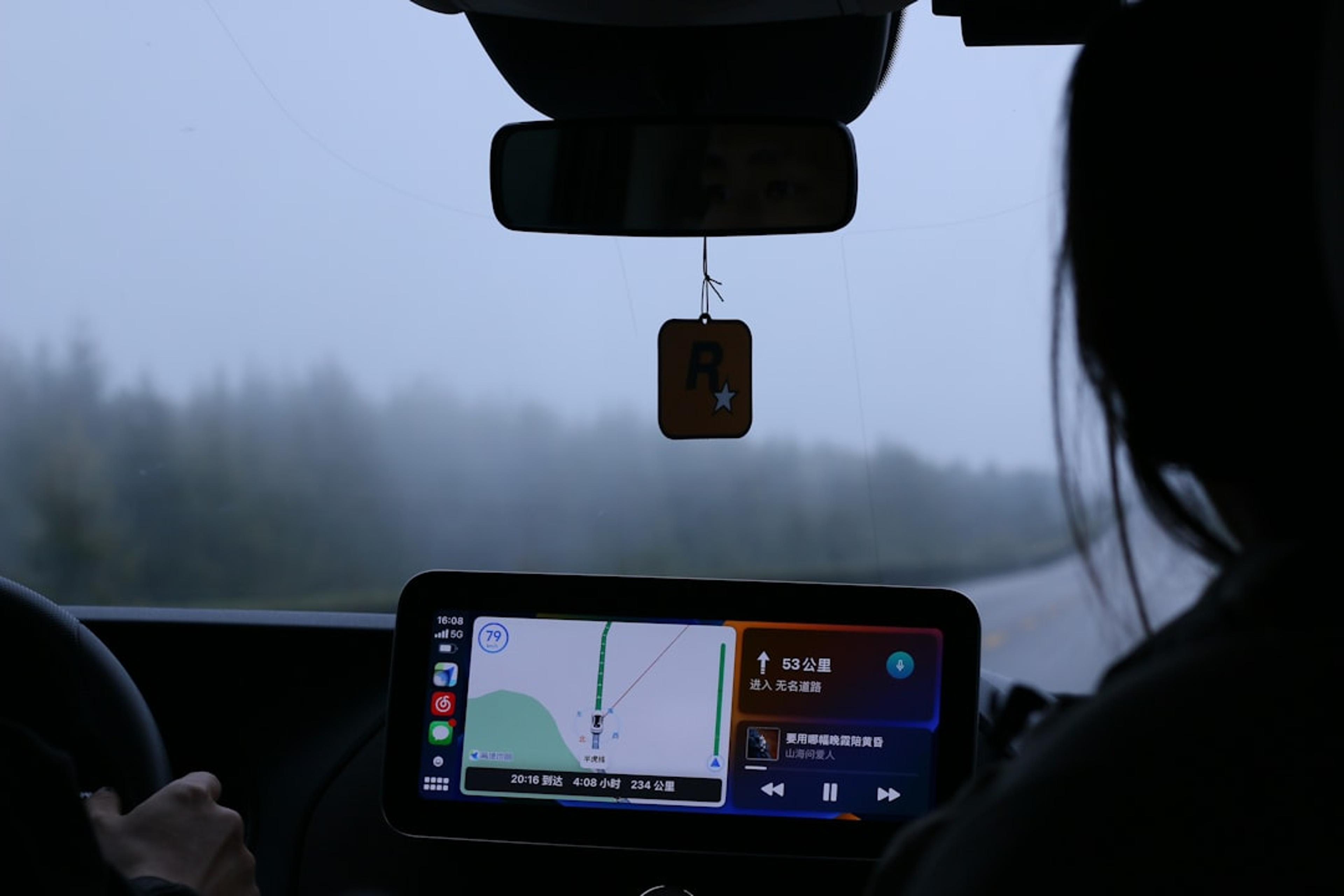 a woman driving a car while holding a cell phone