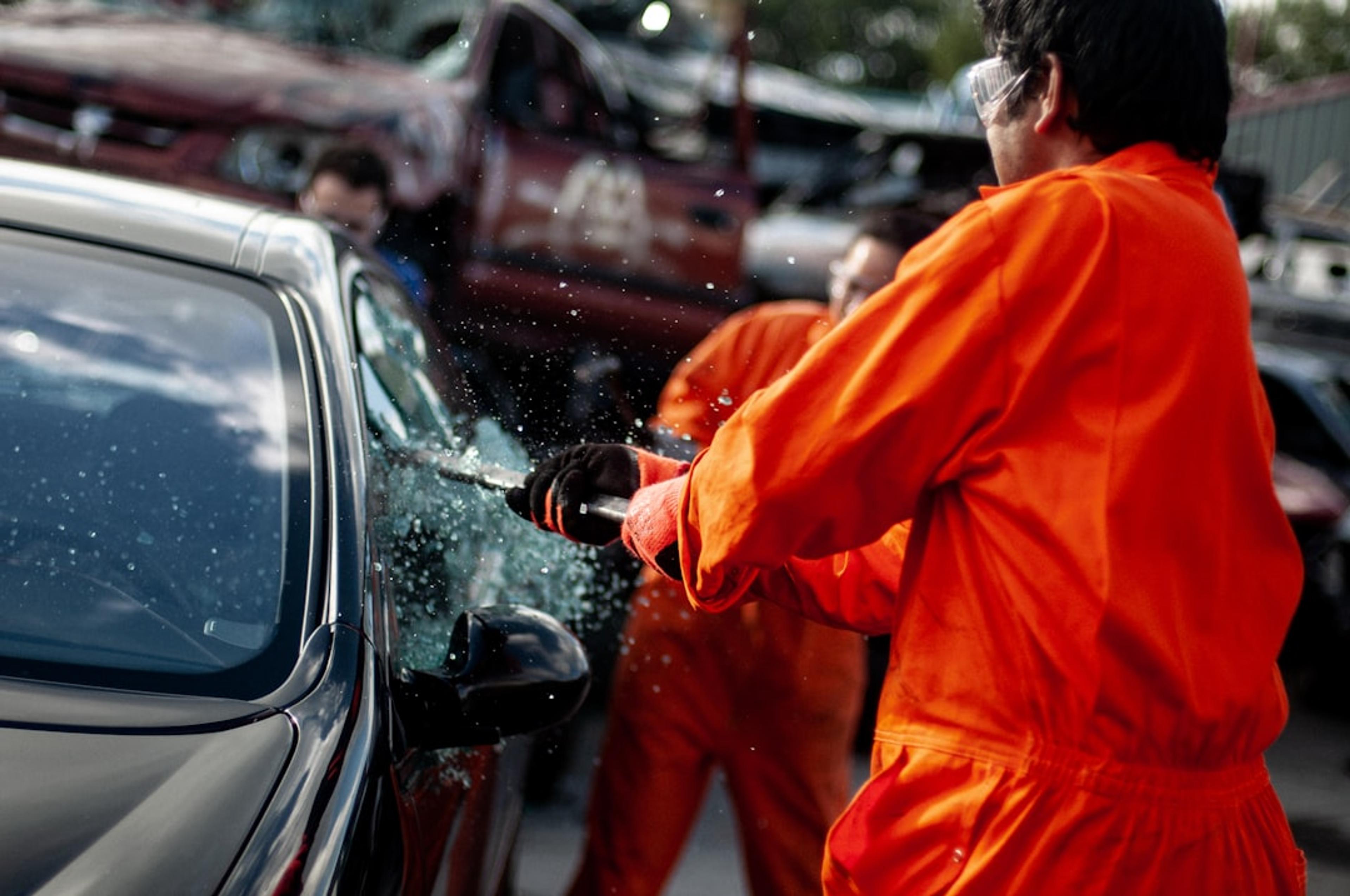 a man in an orange jumpsuit washing a car