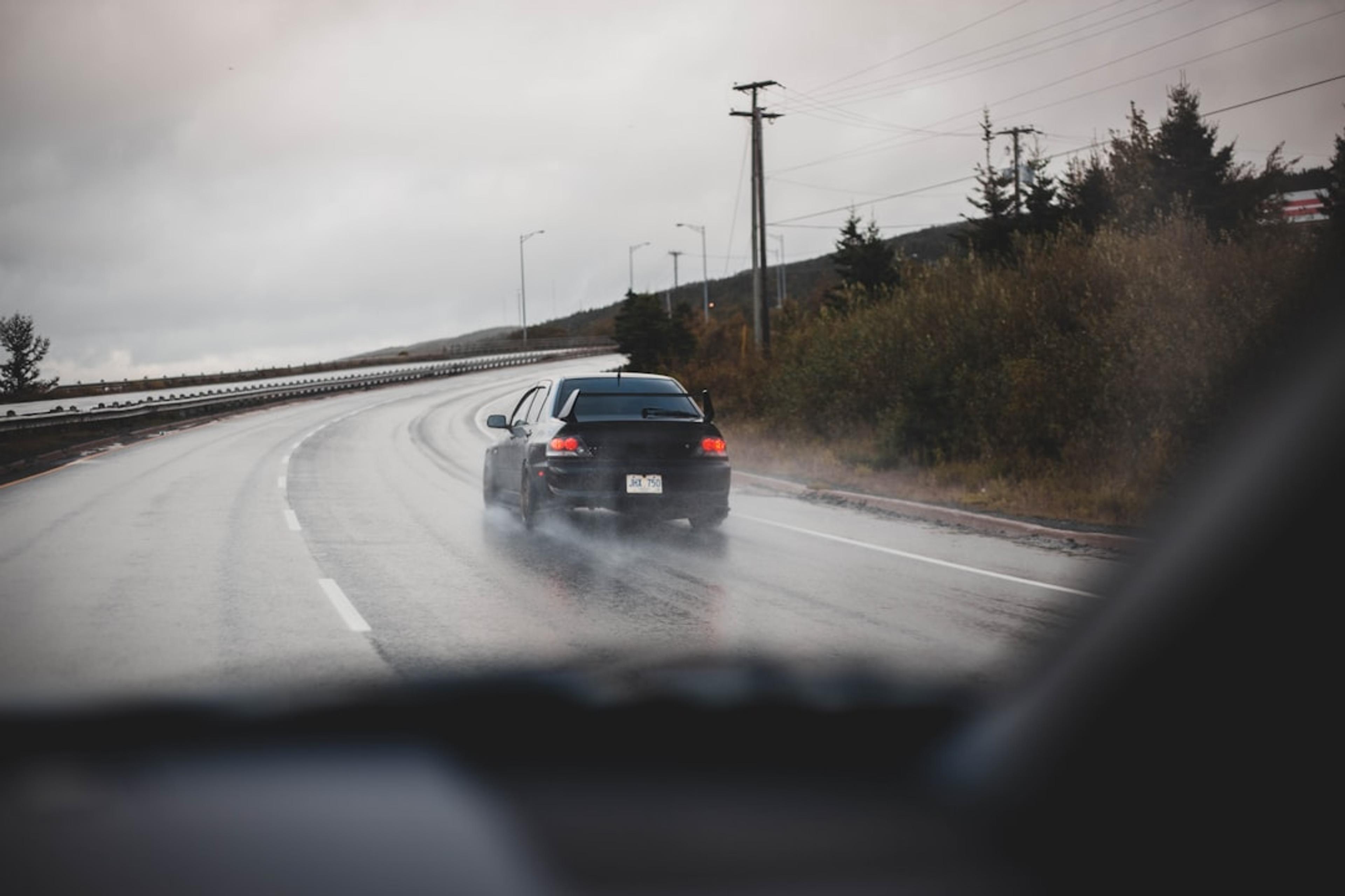 a car driving down the road in the rain