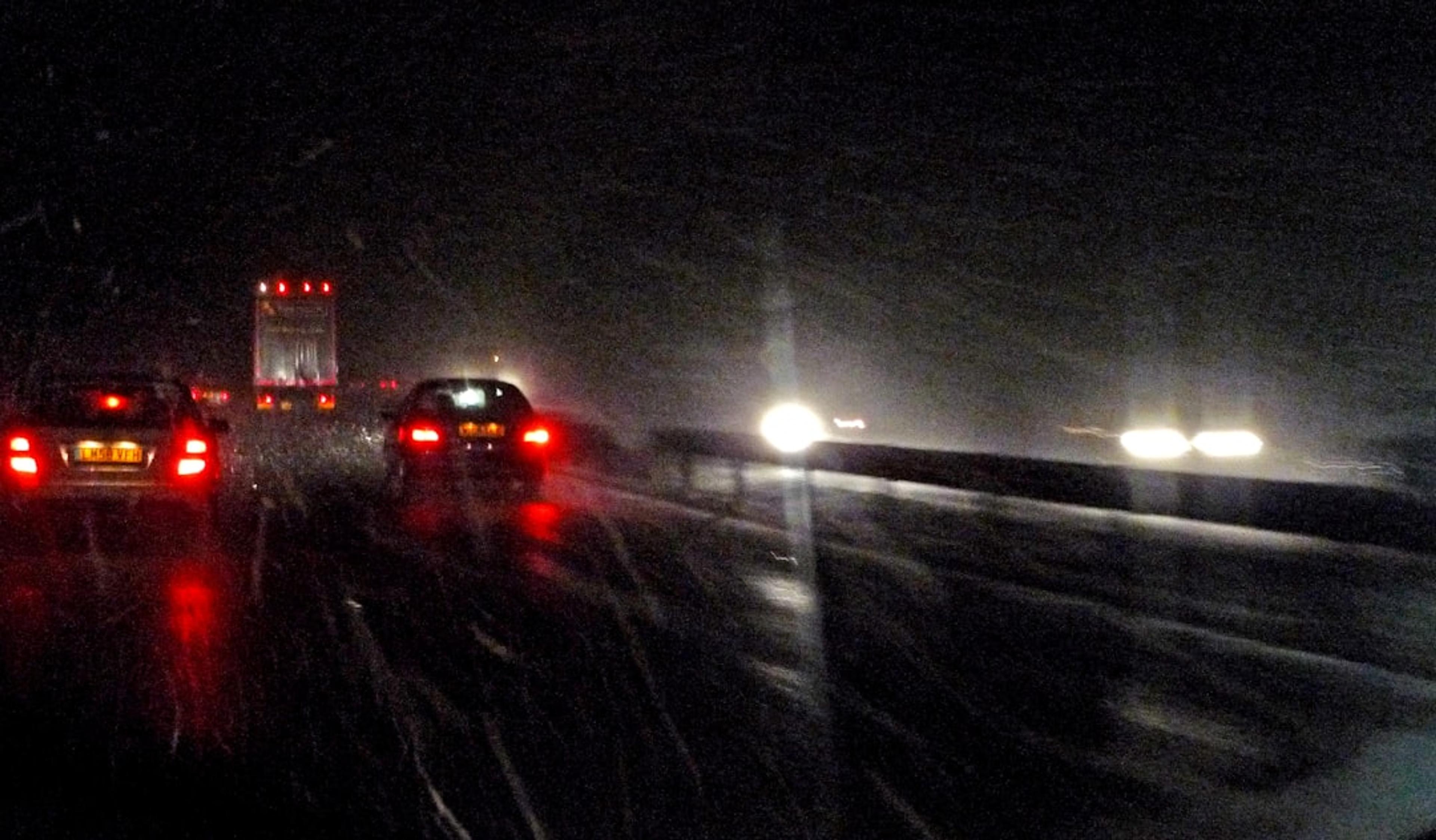 Cars driving on a wet road at night