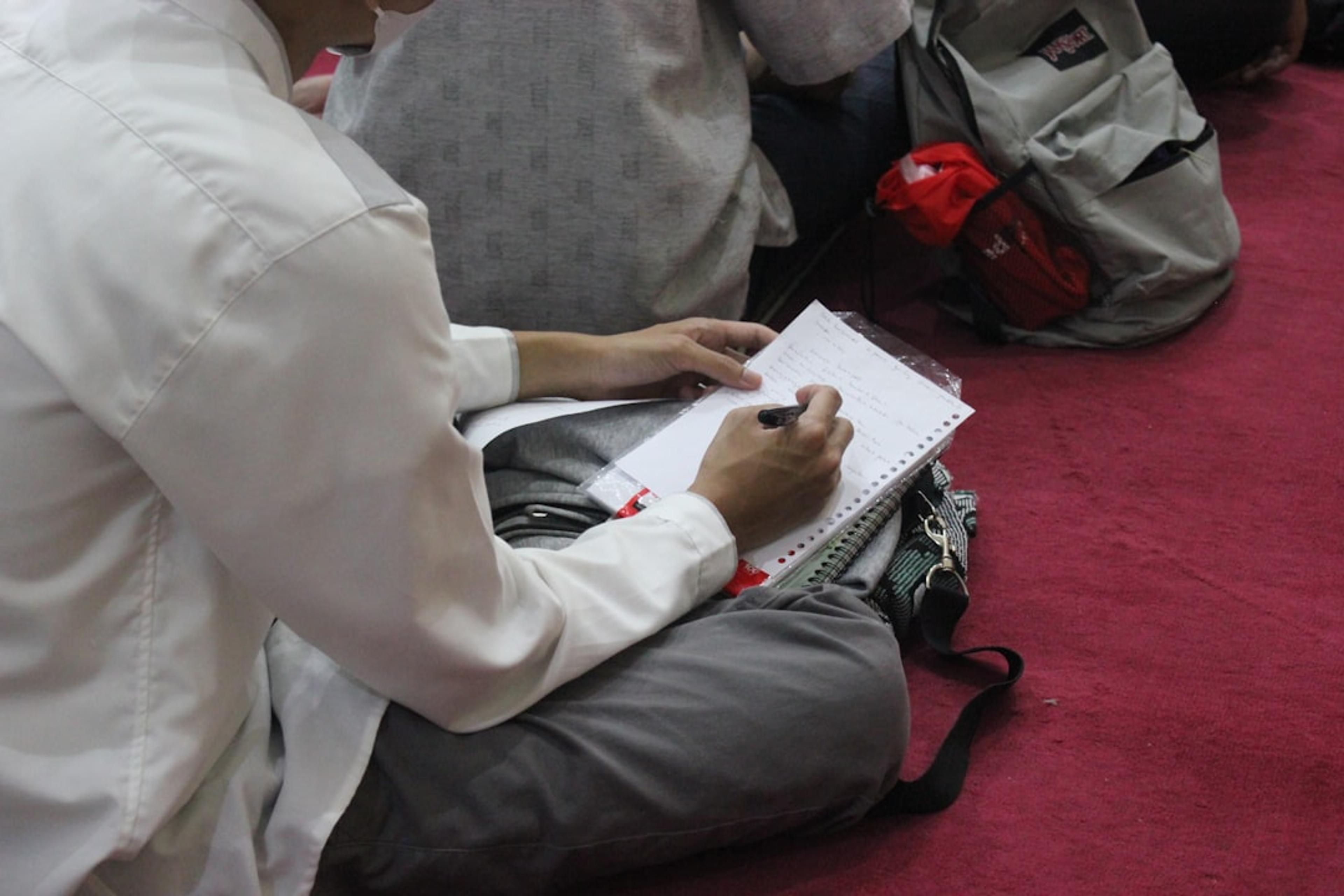 a person writing on a piece of paper