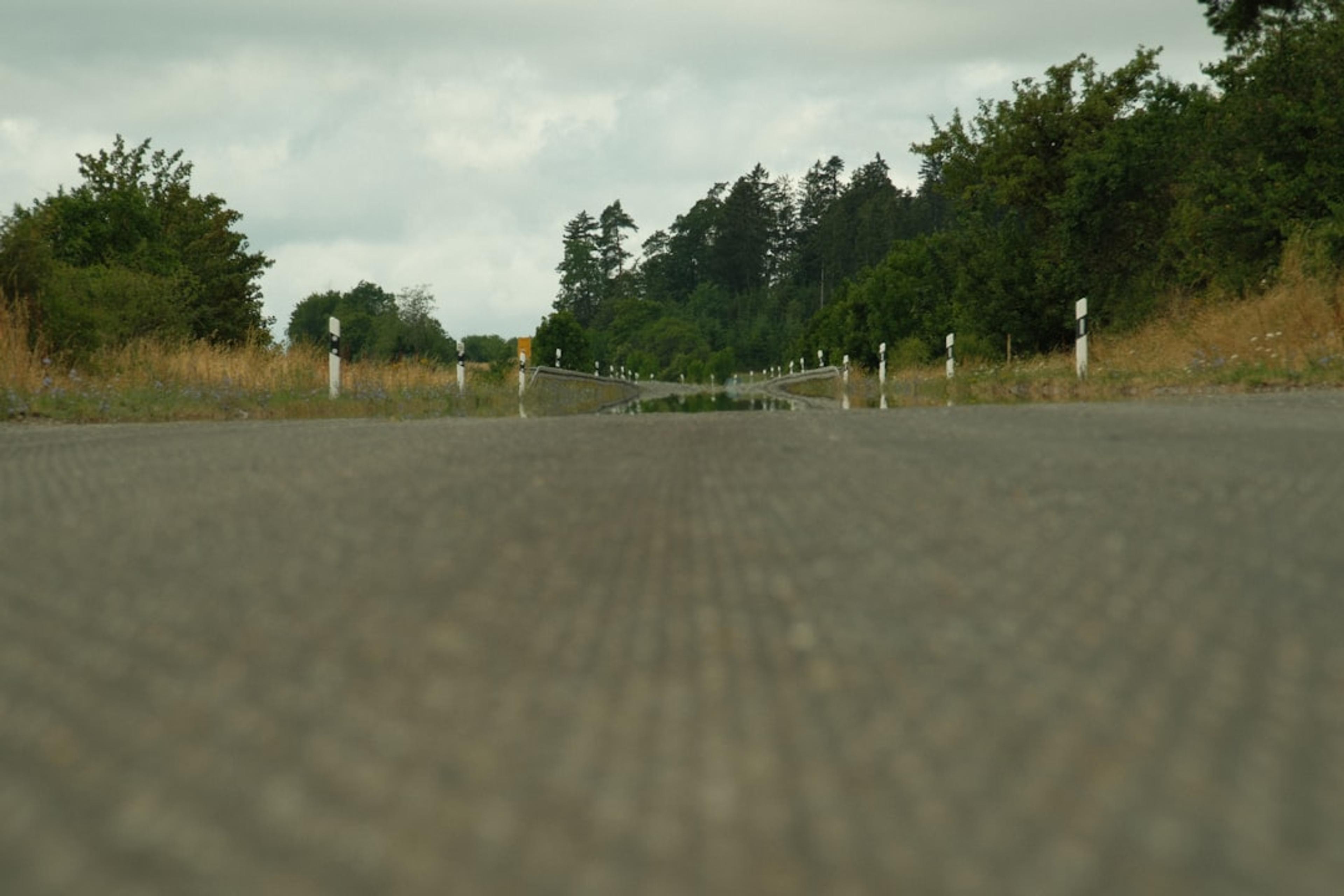 an empty road with a gate in the middle of it