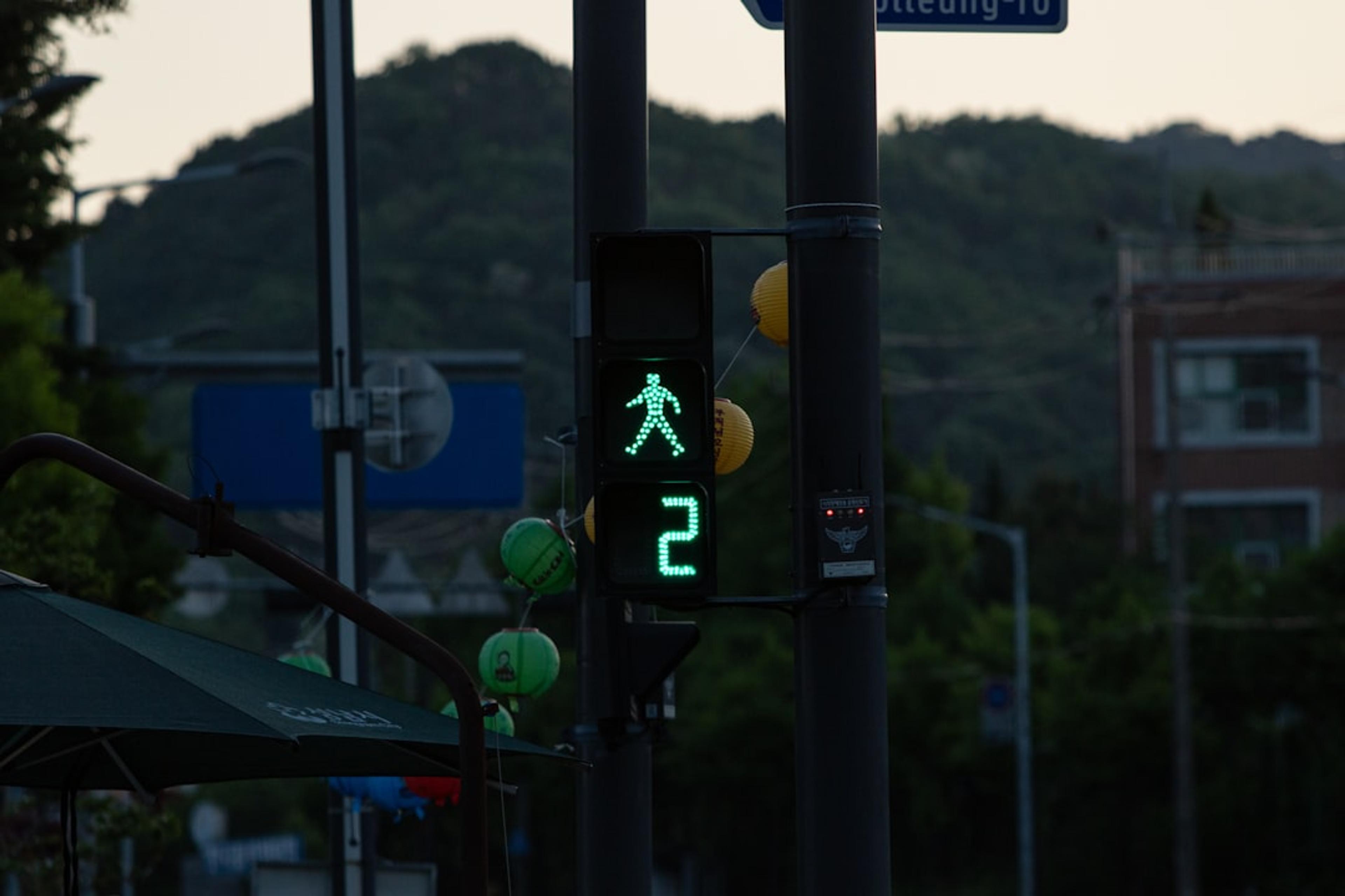 a traffic light with a green pedestrian sign on it