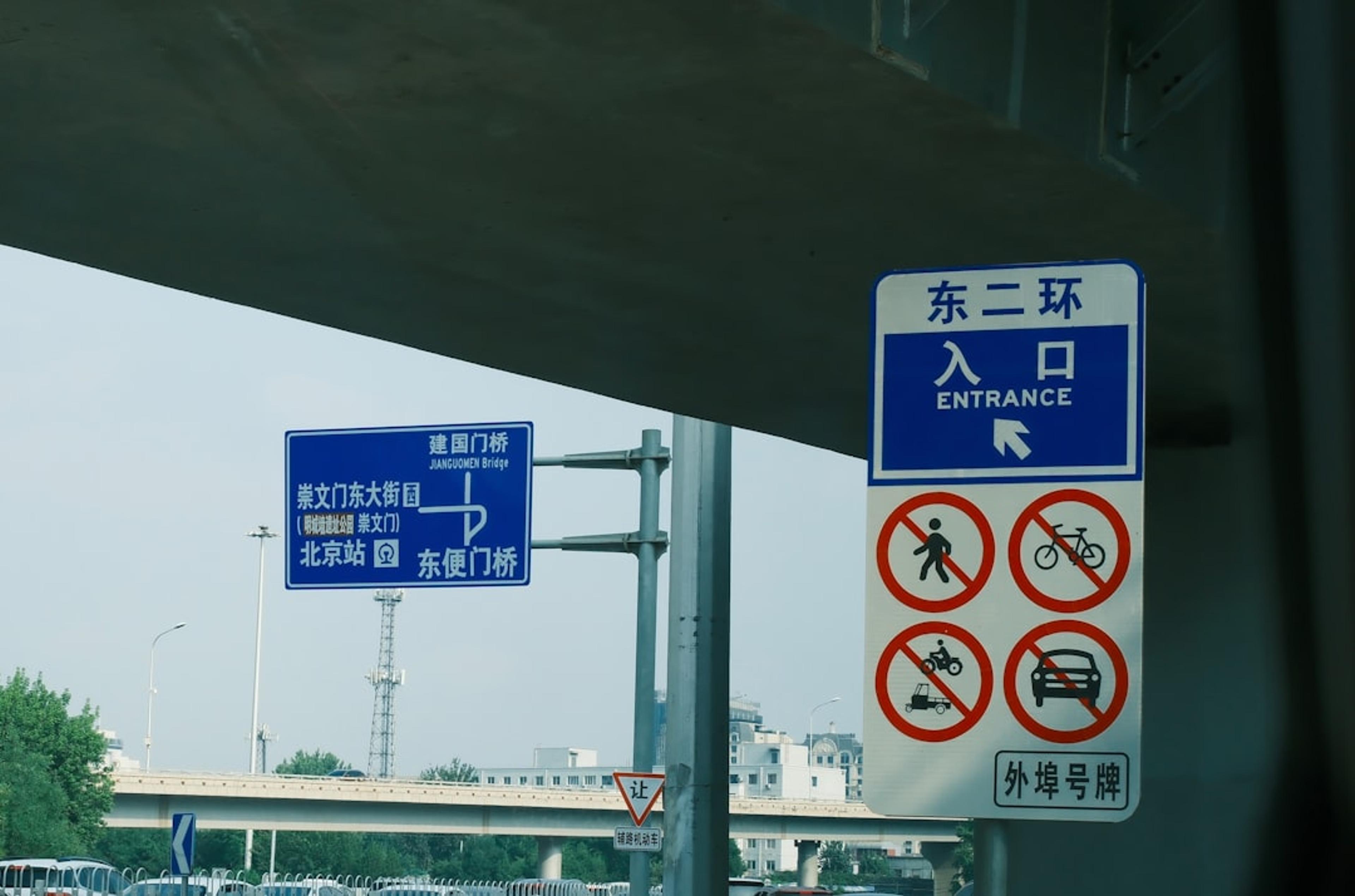 a blue and white street sign next to a highway