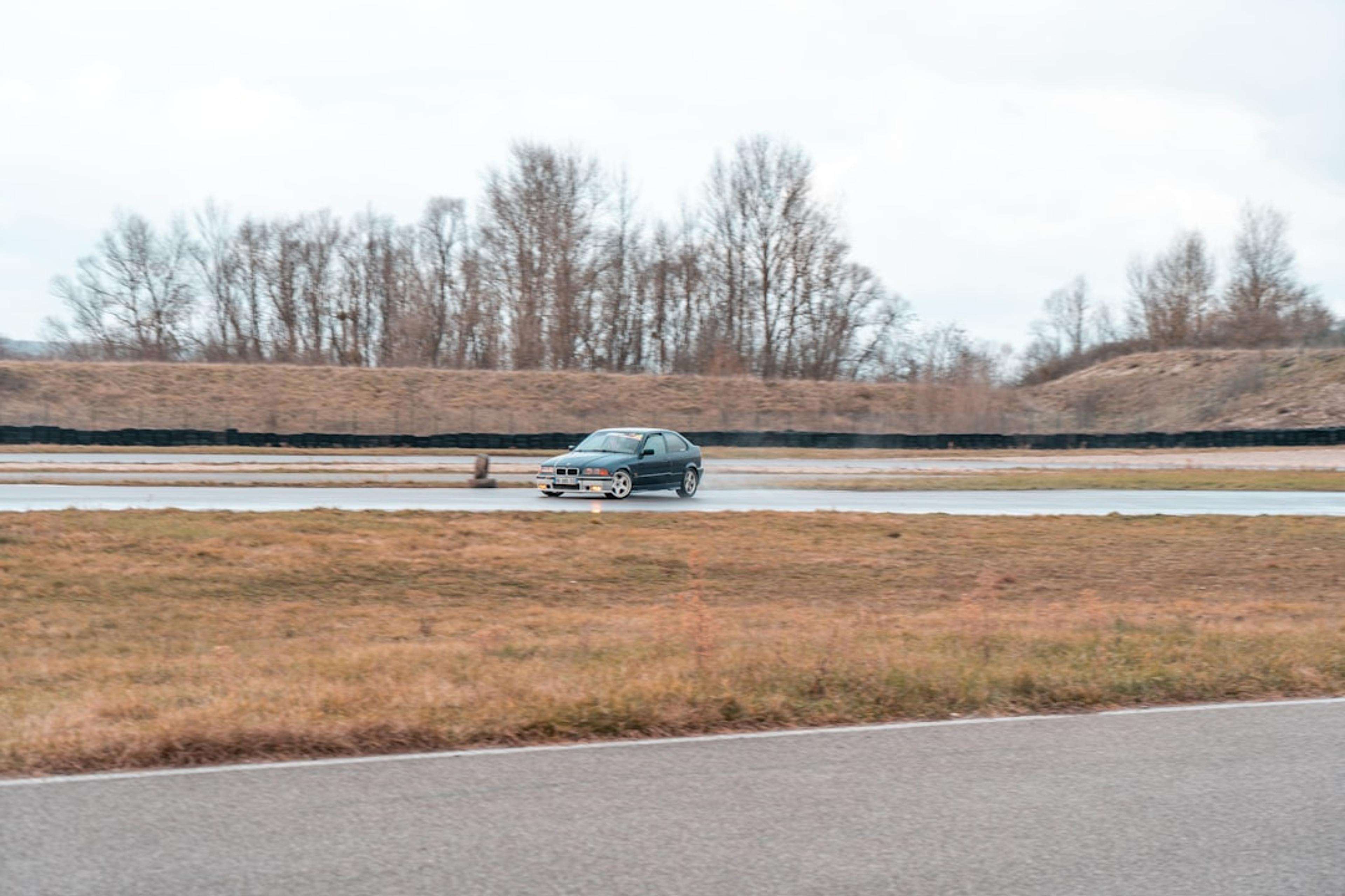 a car driving down a road next to a body of water