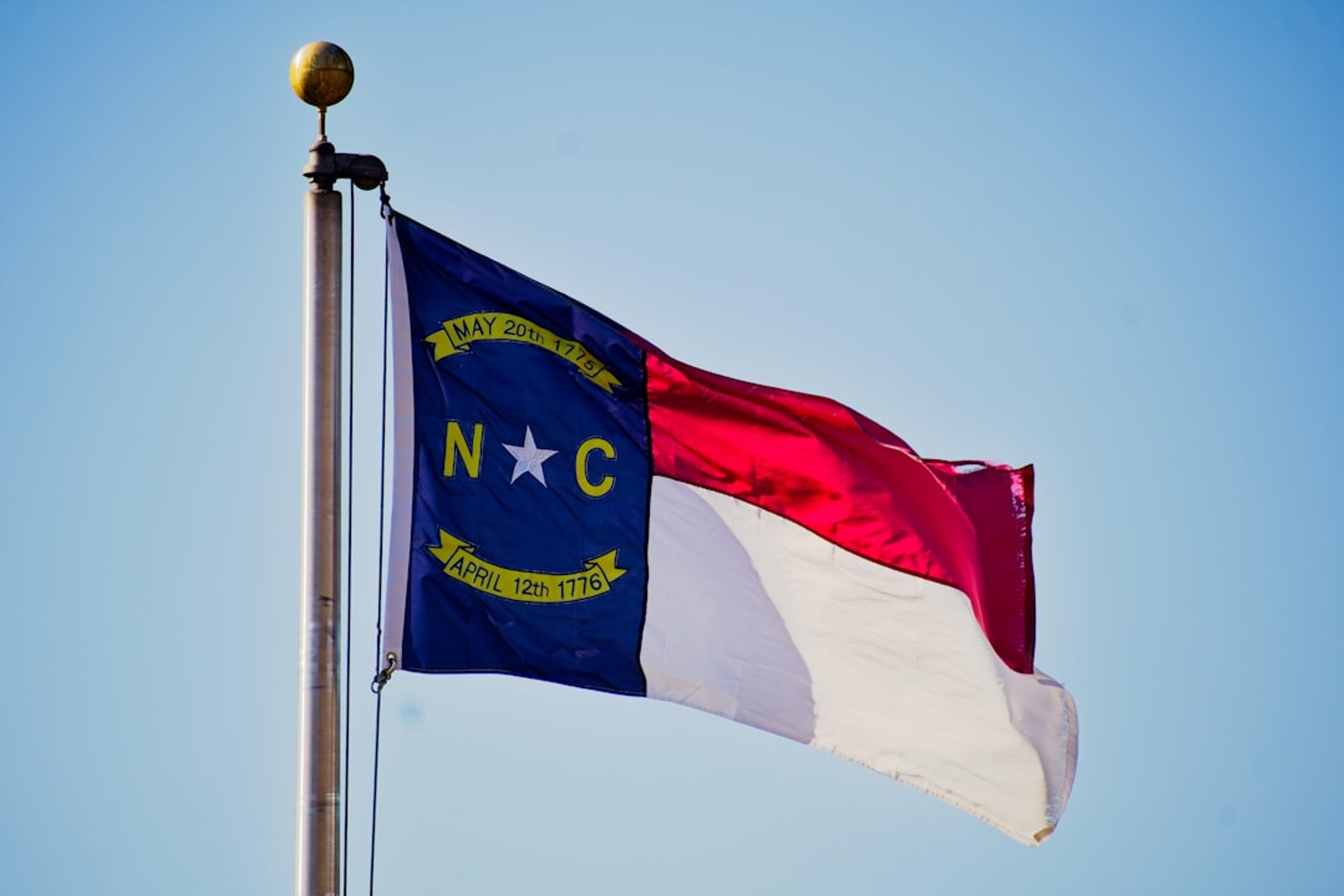 North carolina flag waving against a blue sky