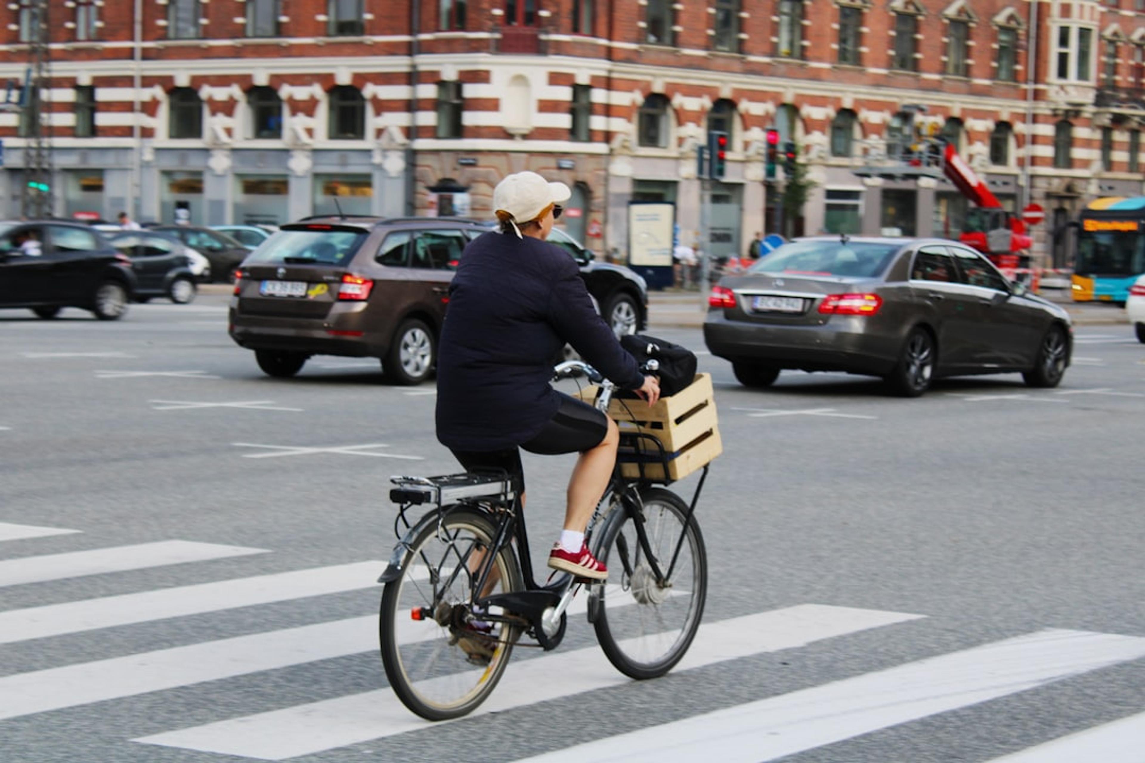 man in black jacket riding bicycle on road during daytime