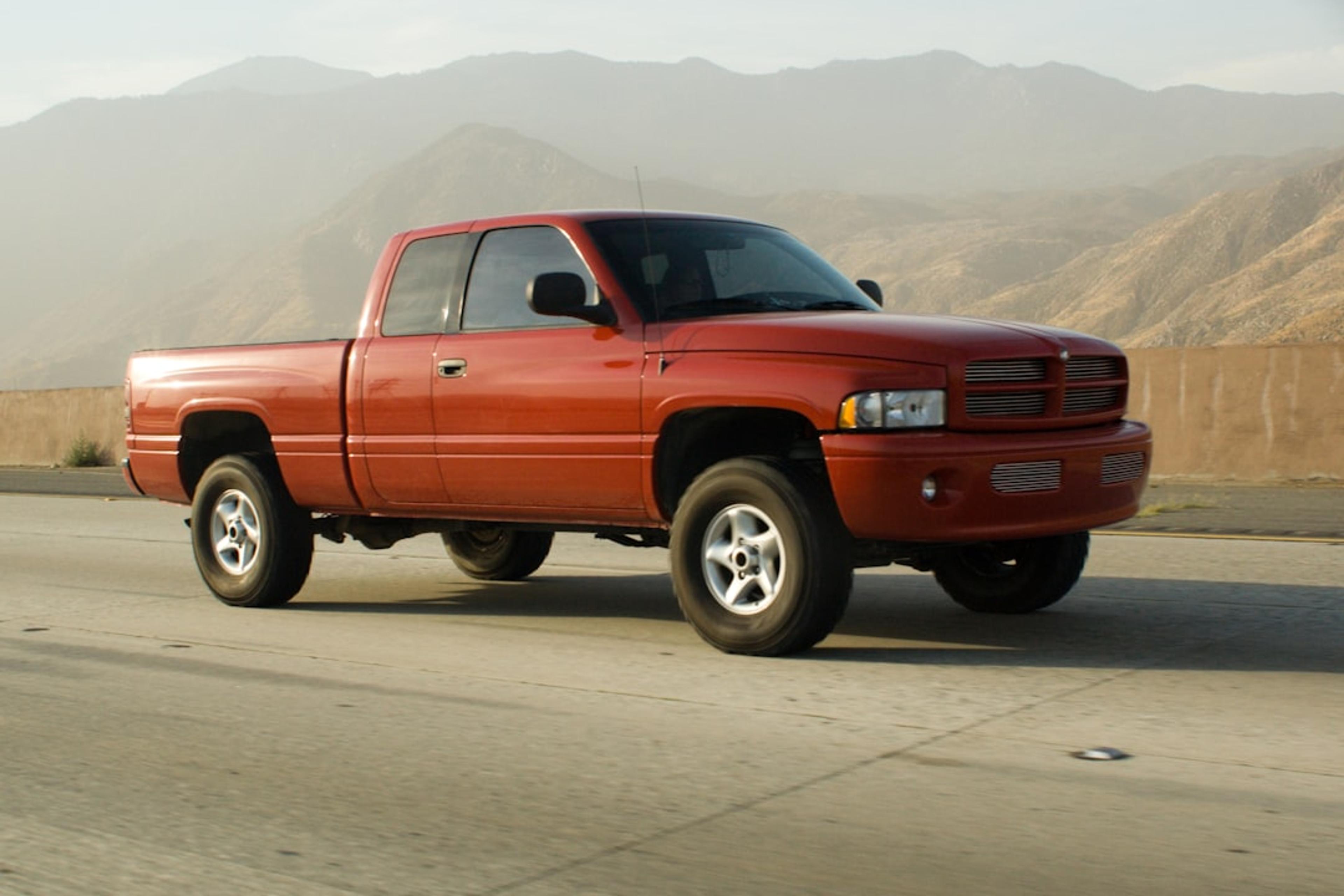 Orange pickup truck driving on a highway.