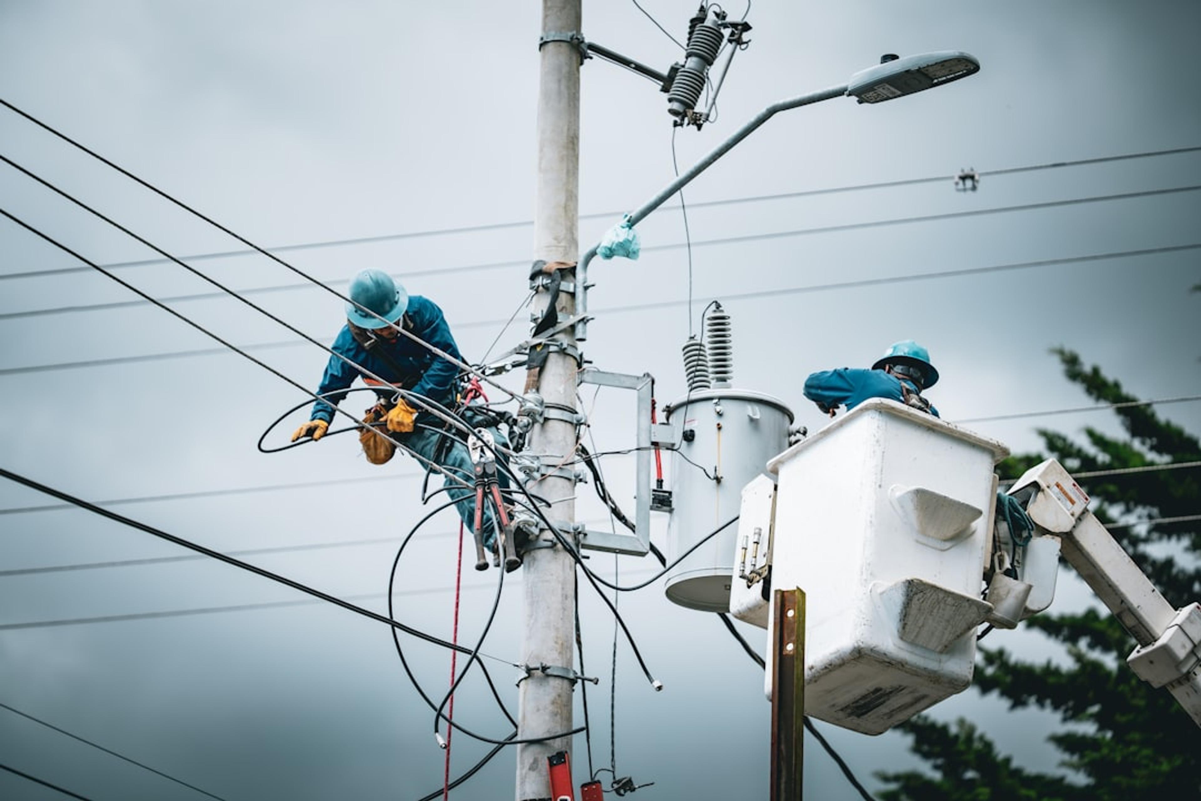 Linemen working on a utility pole with bucket truck.