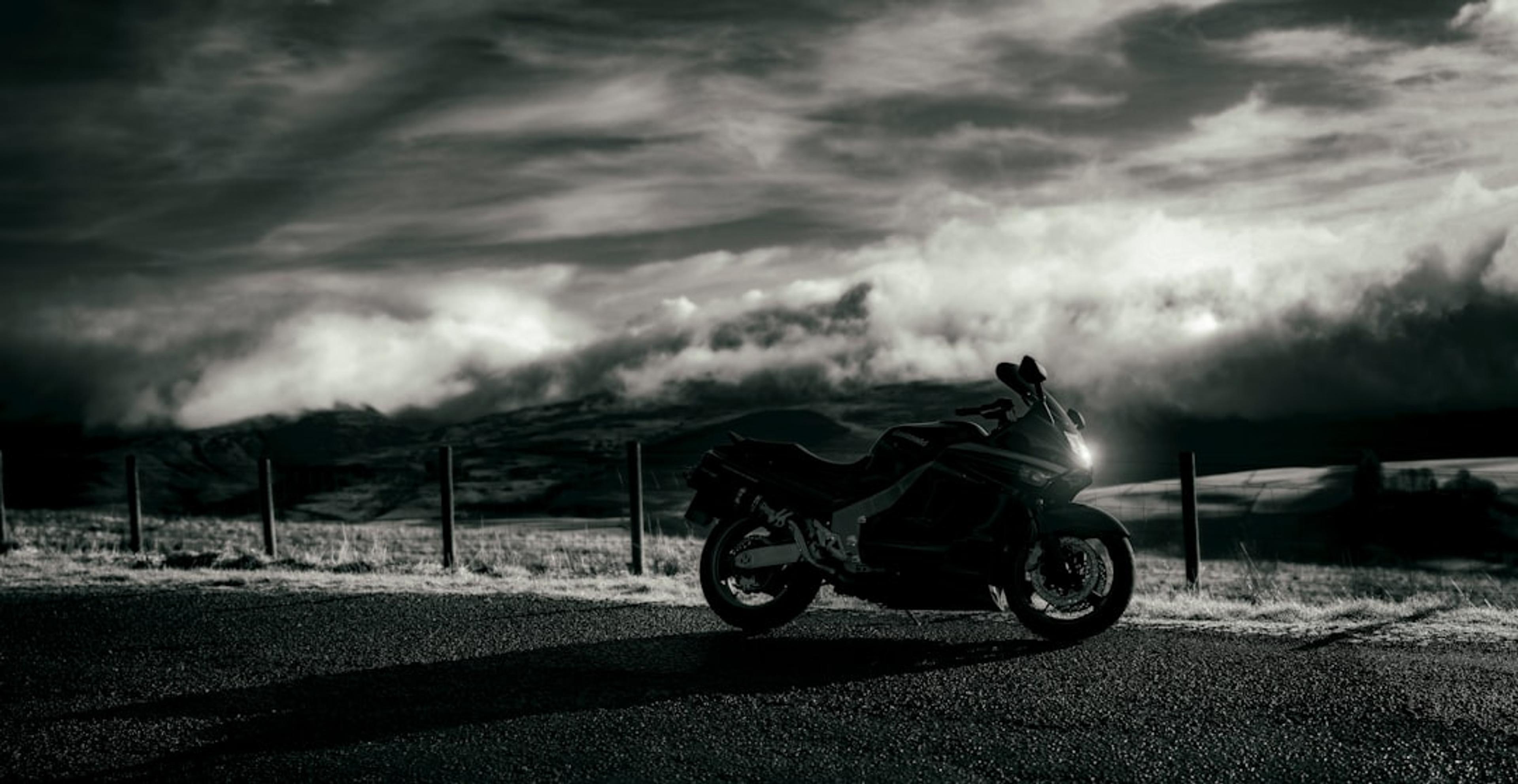 black motorcycle on gray asphalt road under gray cloudy sky