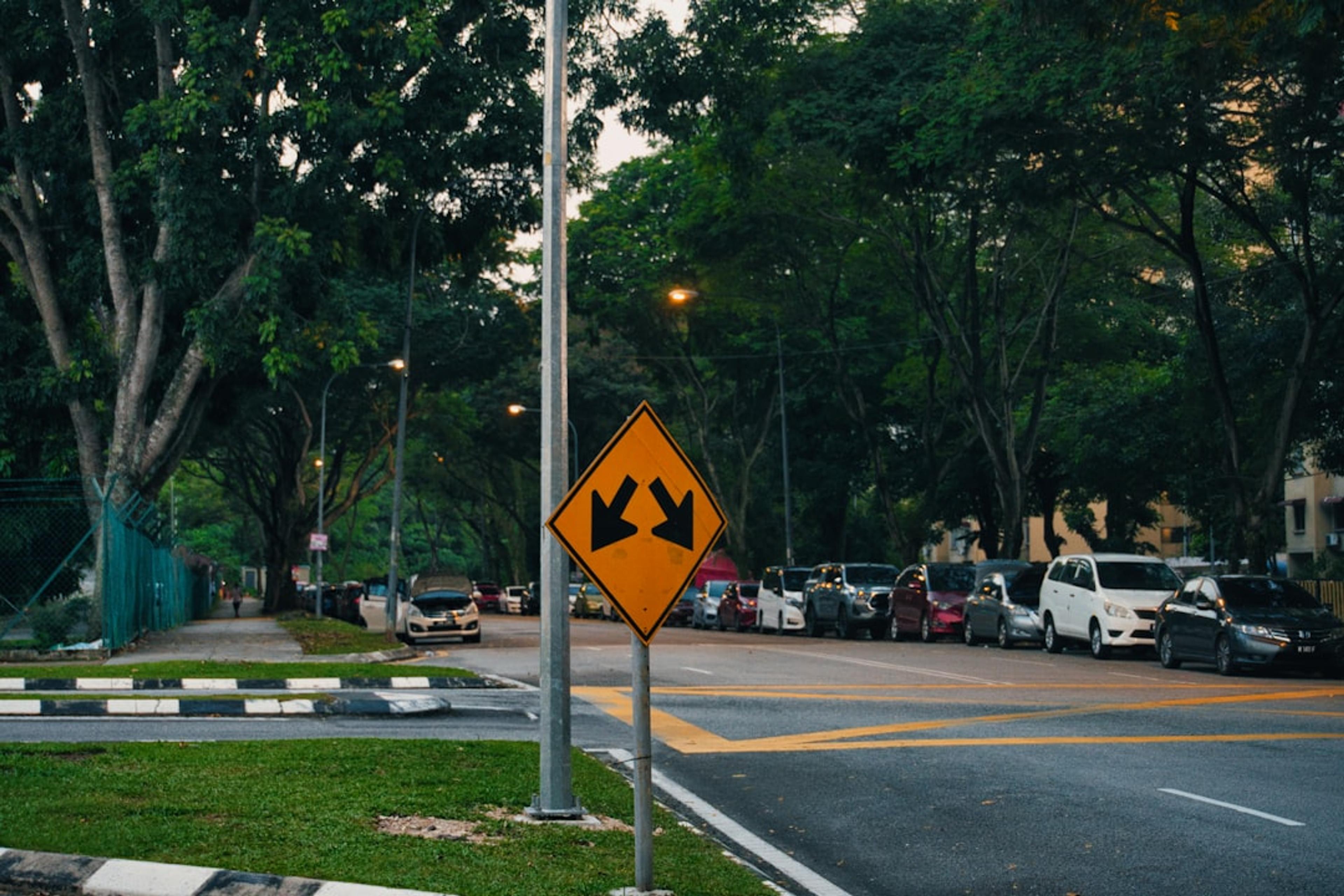 A road sign warns of a divided highway.