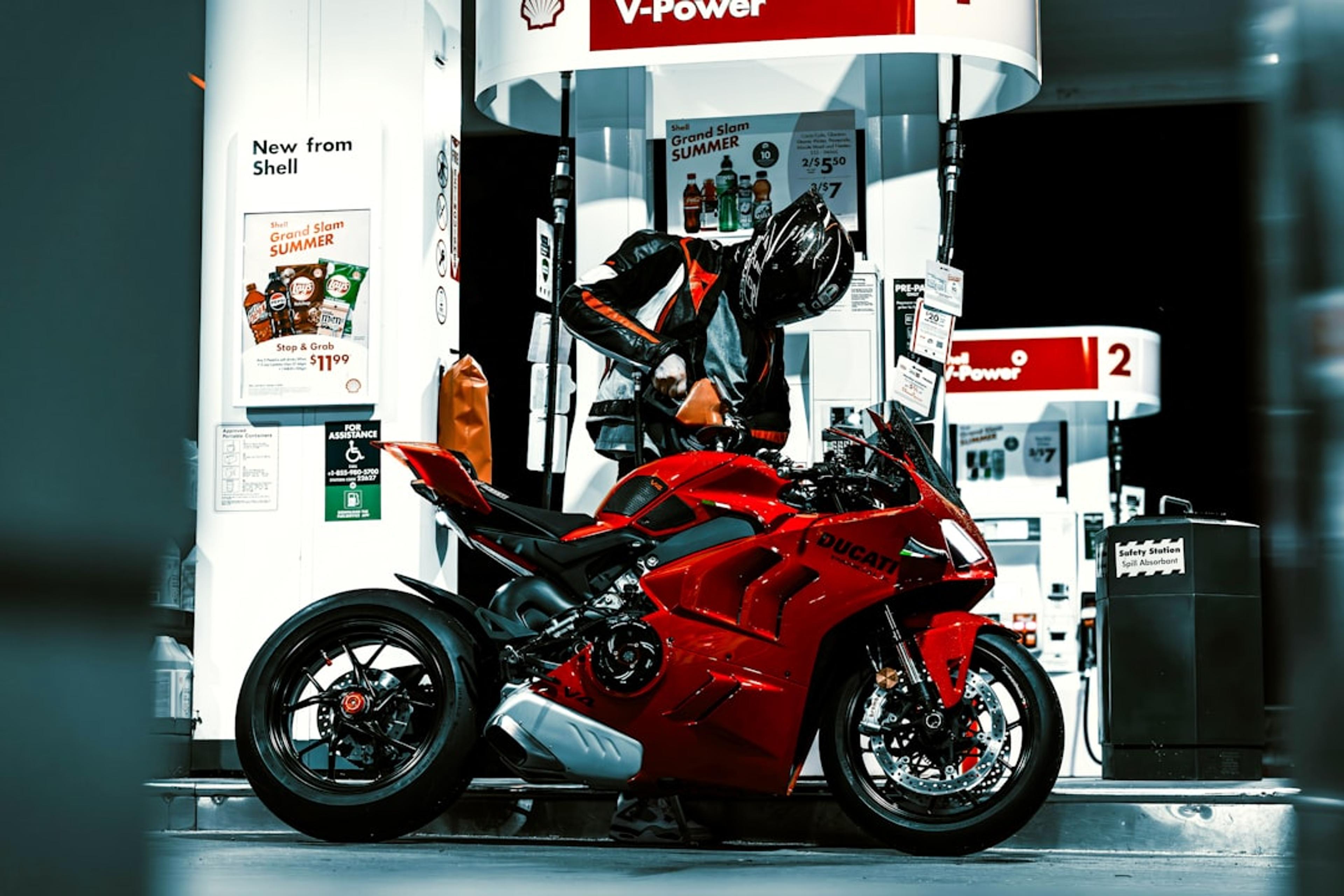 A red motorcycle parked in front of a gas station