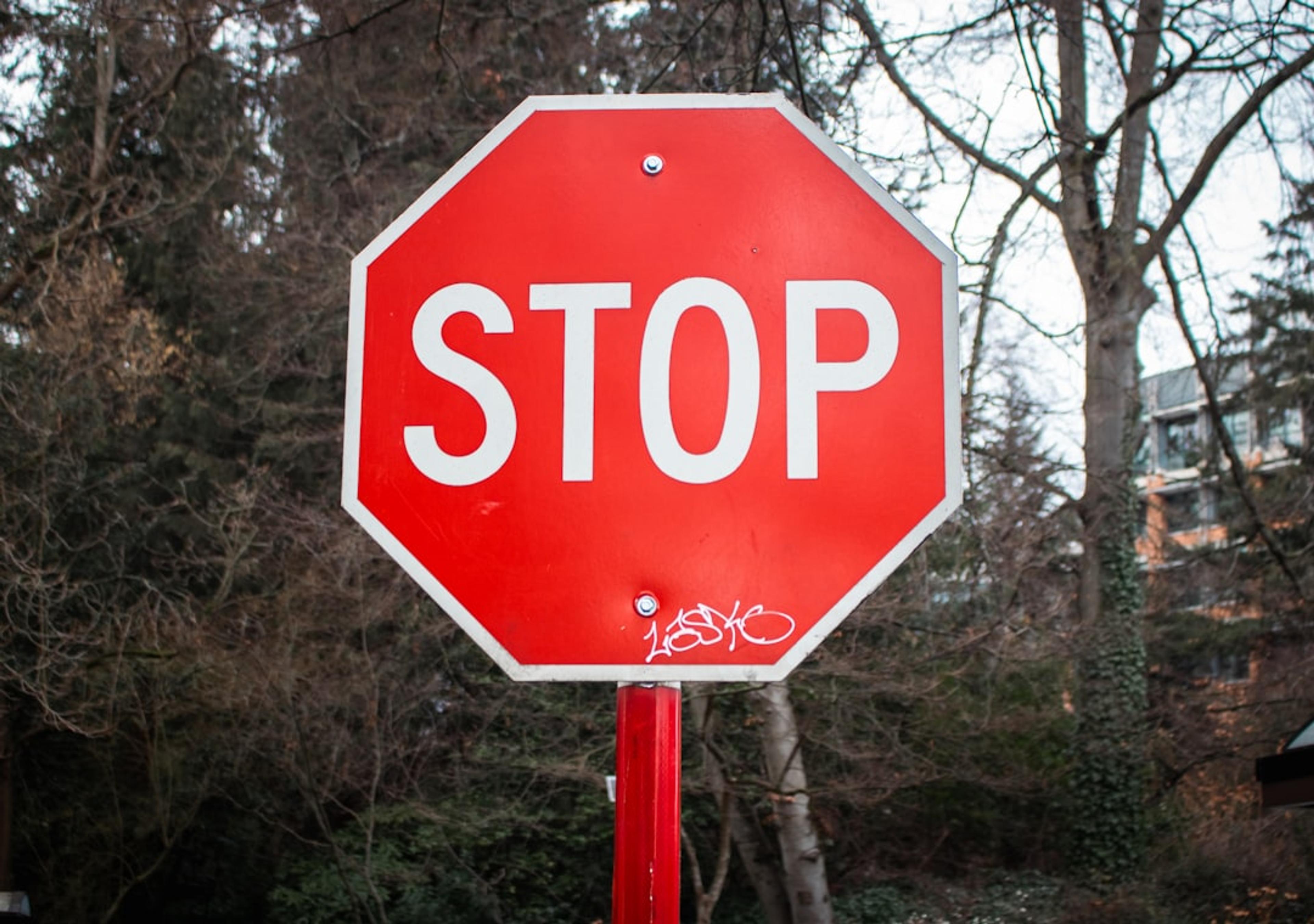 A stop sign is visible in front of trees.