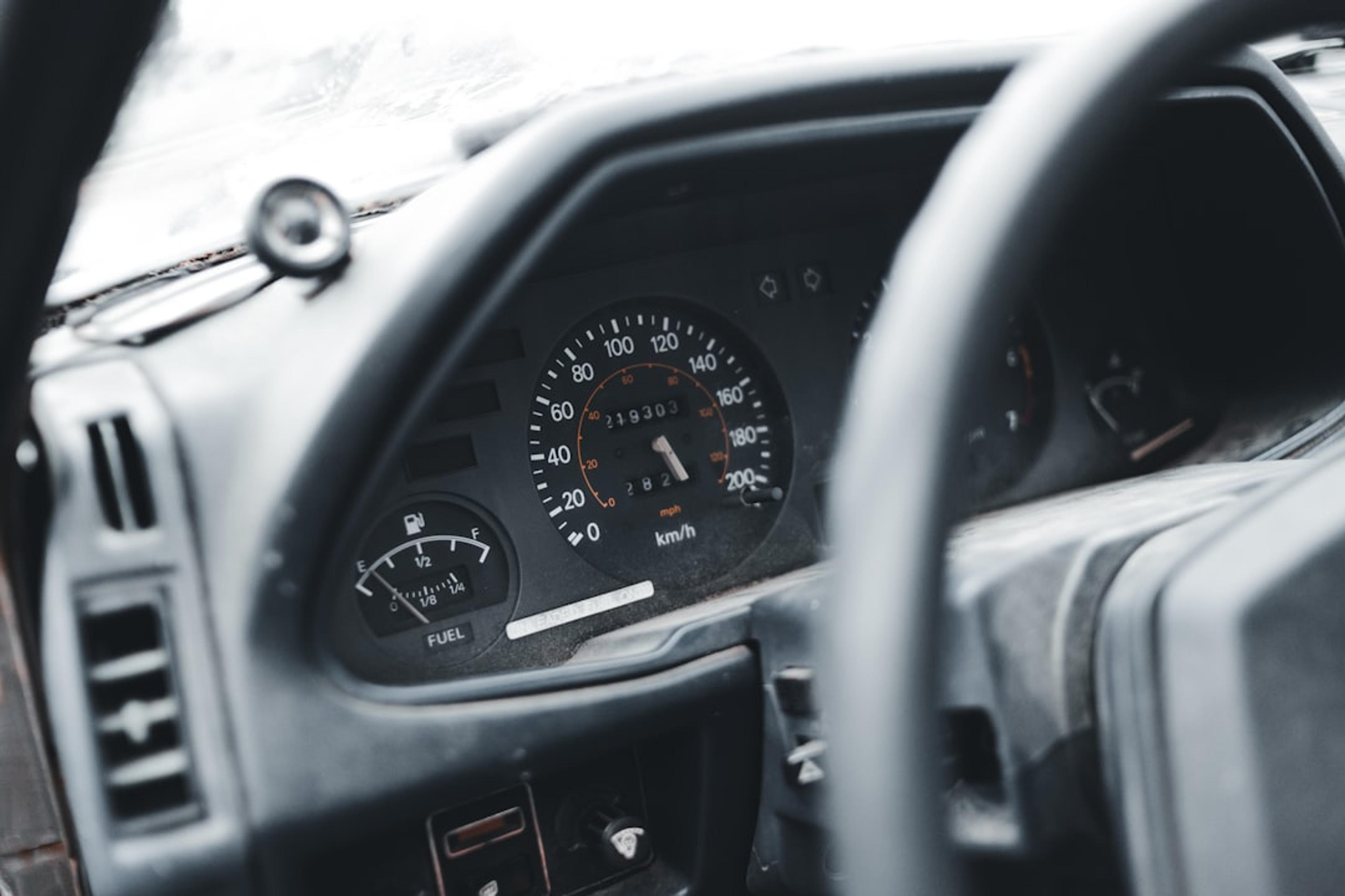 a dashboard of a car with a speedometer and a dash light