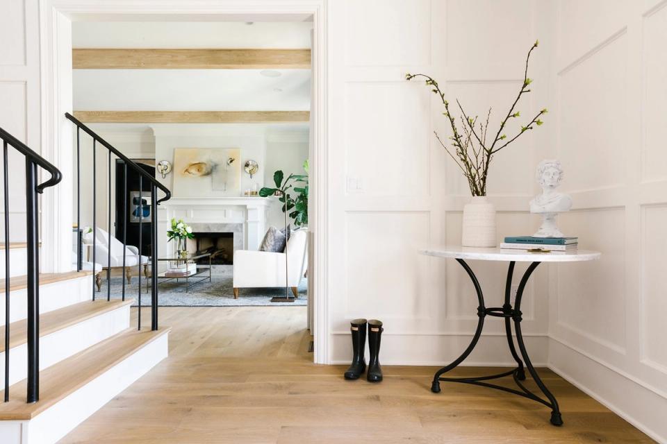 Modern entryway with crisp white walls, natural wood flooring, and minimal styling