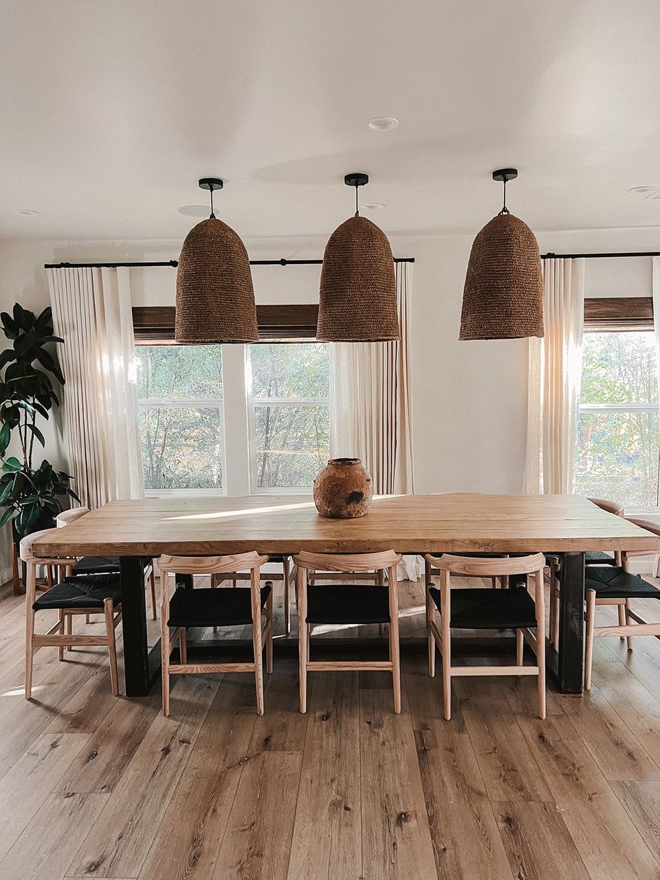 Farmhouse dining space with woven pendant lights, live-edge wood table, and neutral linen aesthetic